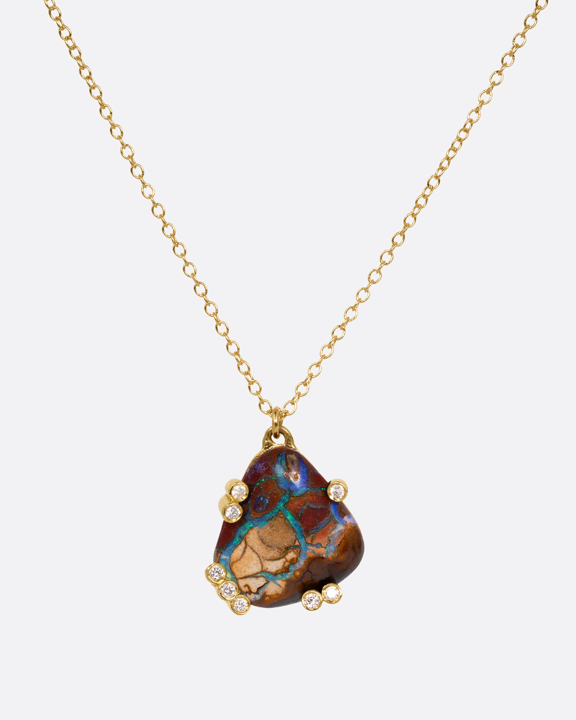 A yellow gold cable chain necklace with a free-form boulder opal and diamond anemones. Shown from the front.