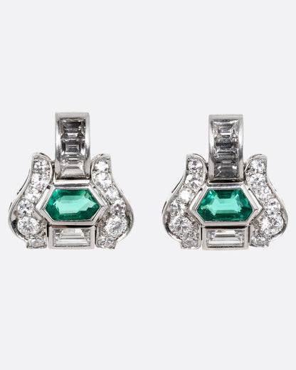 A pair of platinum earrings with emeralds and diamonds, shown from the front.