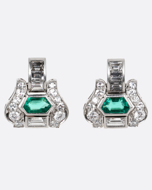 A pair of platinum earrings with emeralds and diamonds, shown from the front.