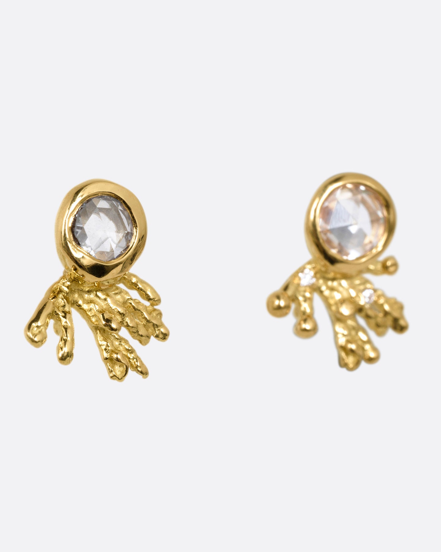 A pair of yellow gold studs earrings with rose cut diamonds and yellow gold comet-like tails. Shown from the side.