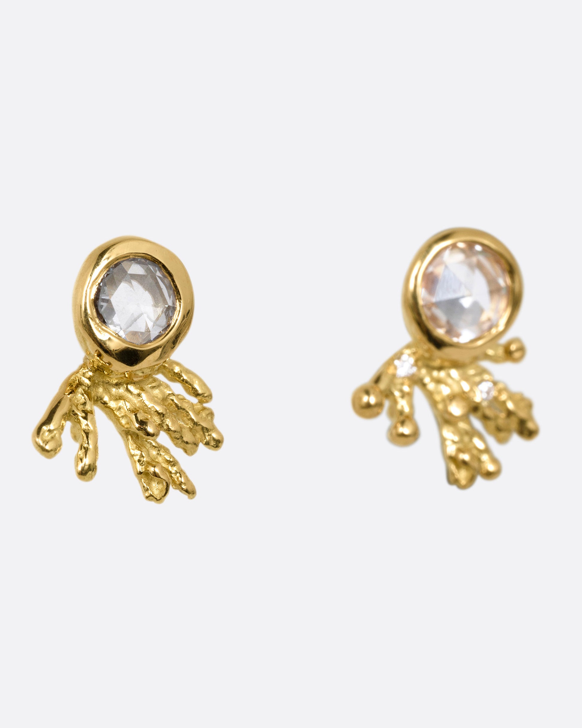 A pair of yellow gold studs earrings with rose cut diamonds and yellow gold comet-like tails. Shown from the side.
