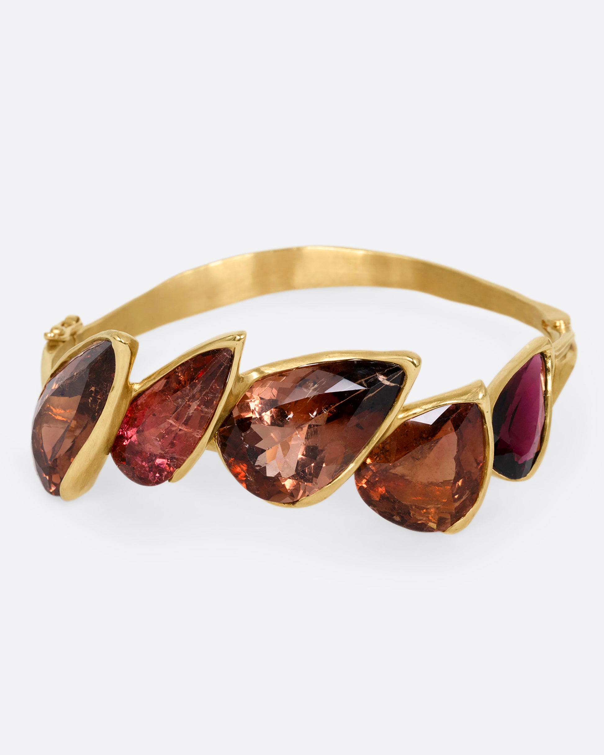 A yellow gold bracelet with five teardrop shaped tourmalines, shown from the front.