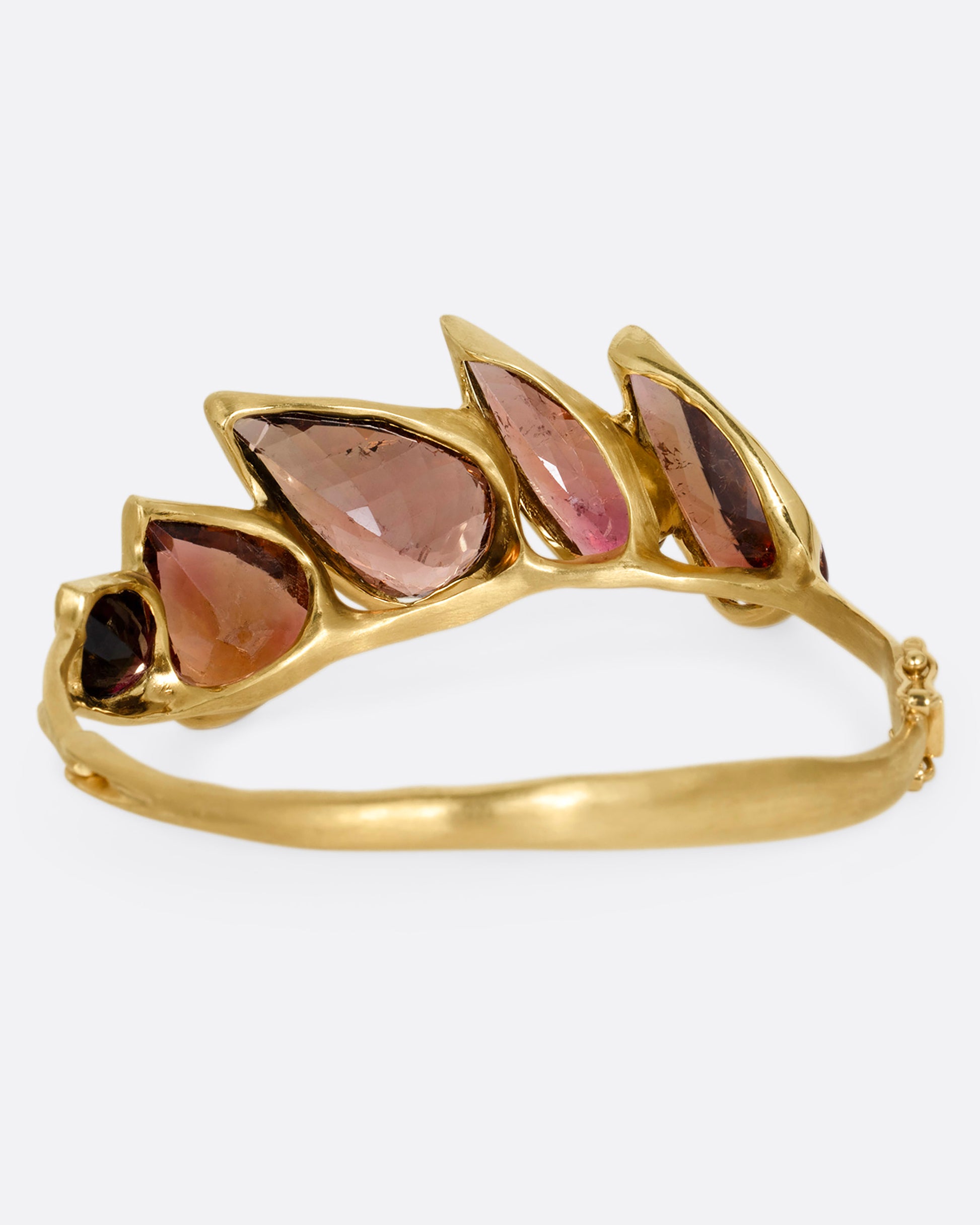 A yellow gold bracelet with five teardrop shaped tourmalines, shown from the back.