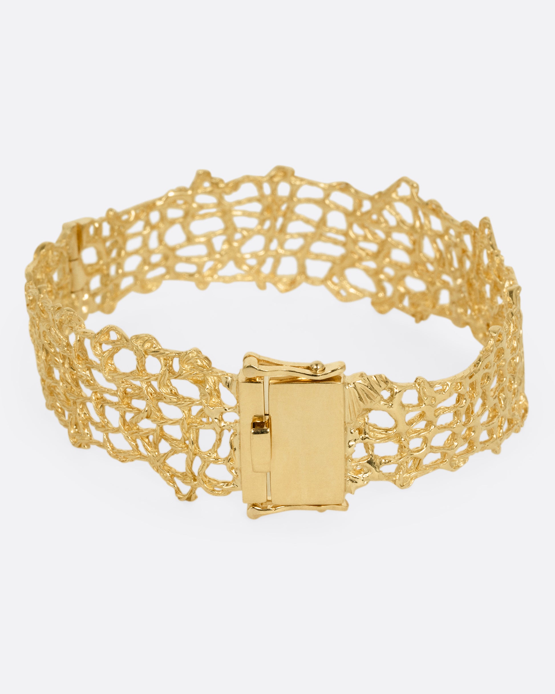 A woven yellow gold wire strand bracelet shown from the back.