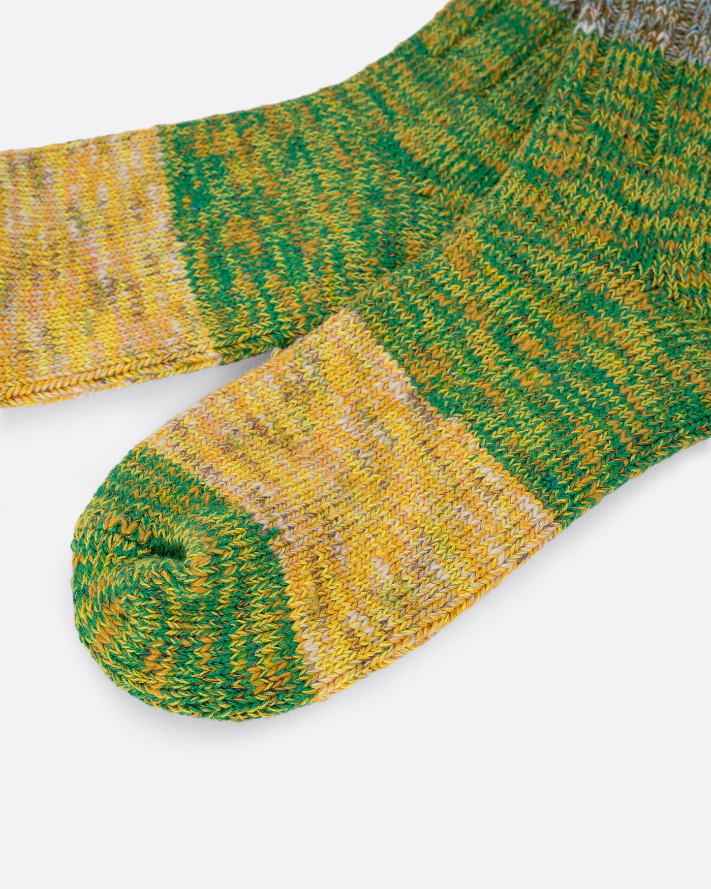 A pair of green, yellow and brown melange ribbed socks. View close up.