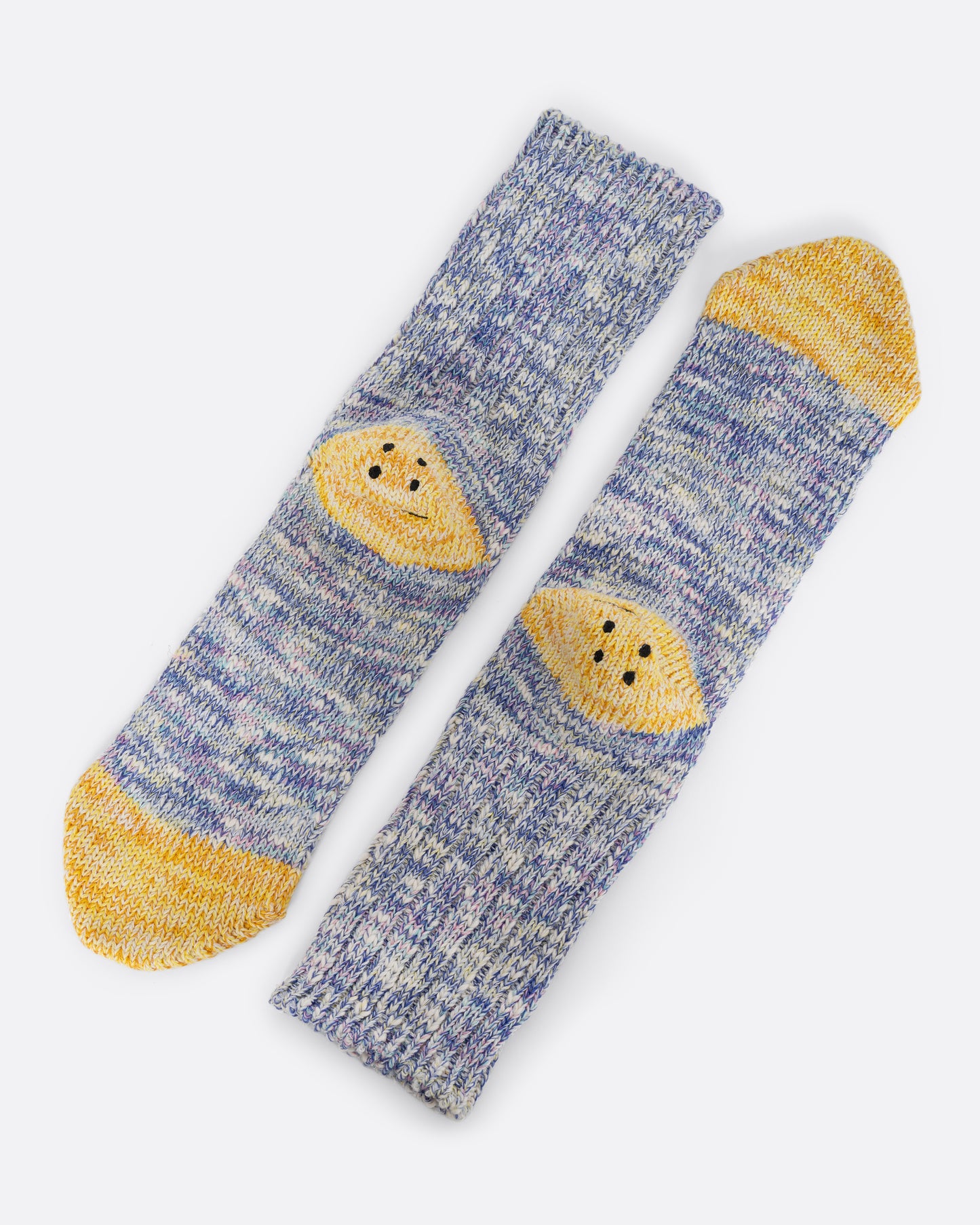 A pair of cotton blend melange purple socks with yellow smiley heels. View laying flat.