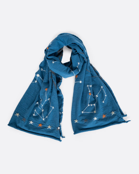 A light blue scarf with constellations novelty knit. Shown loosely tied.