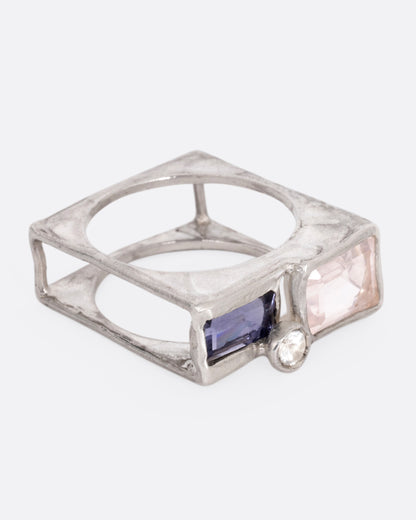 A silver square cage ring with a quartz, iolite, and topaz, shown from the side.