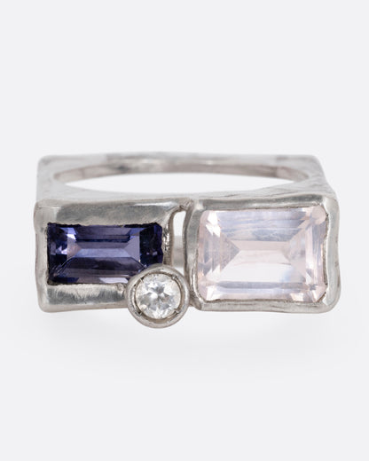 A silver square cage ring with a quartz, iolite, and topaz, shown from the front.