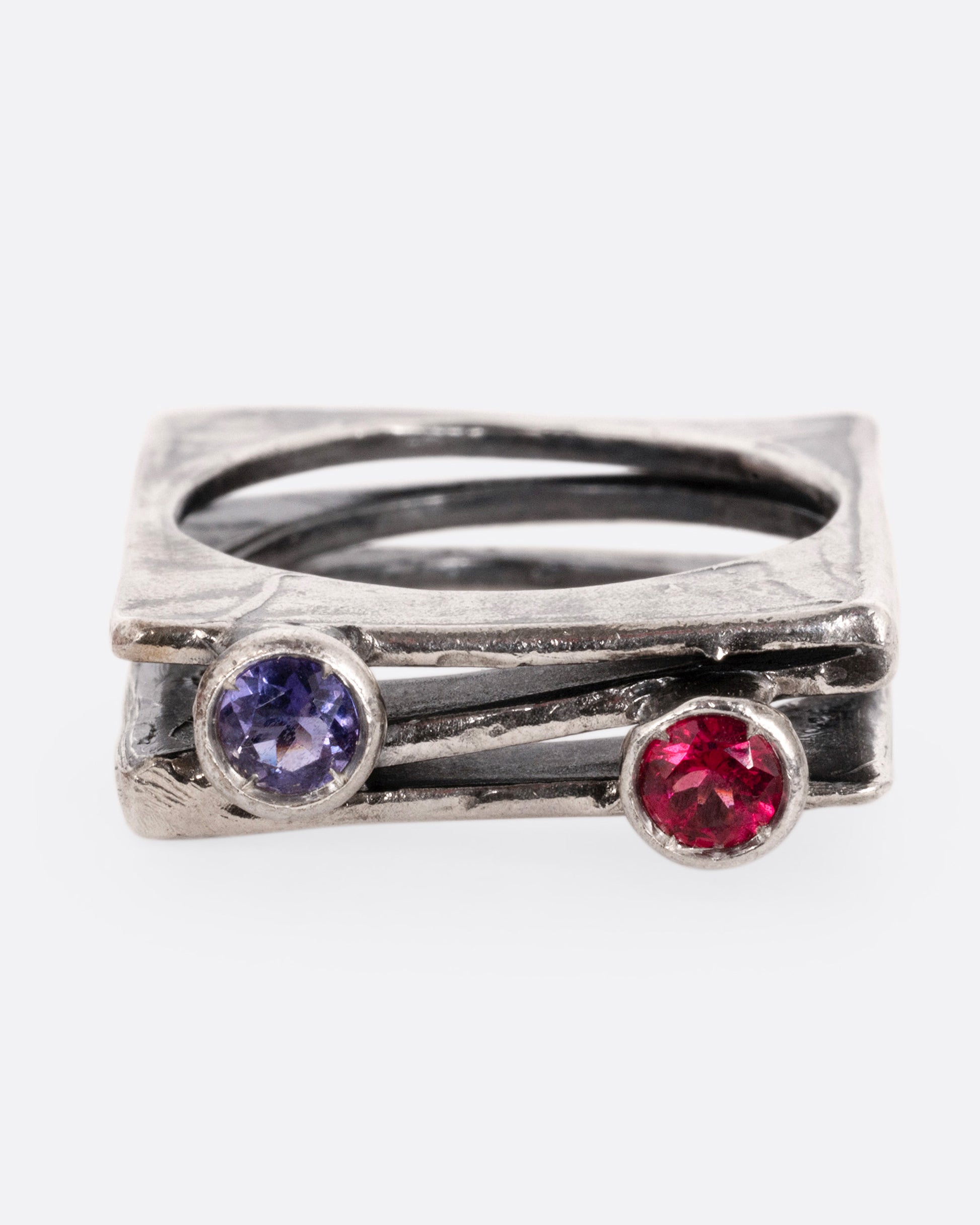 A silver stacked square ring with a blue sapphire and a pink sapphire shown from the front.