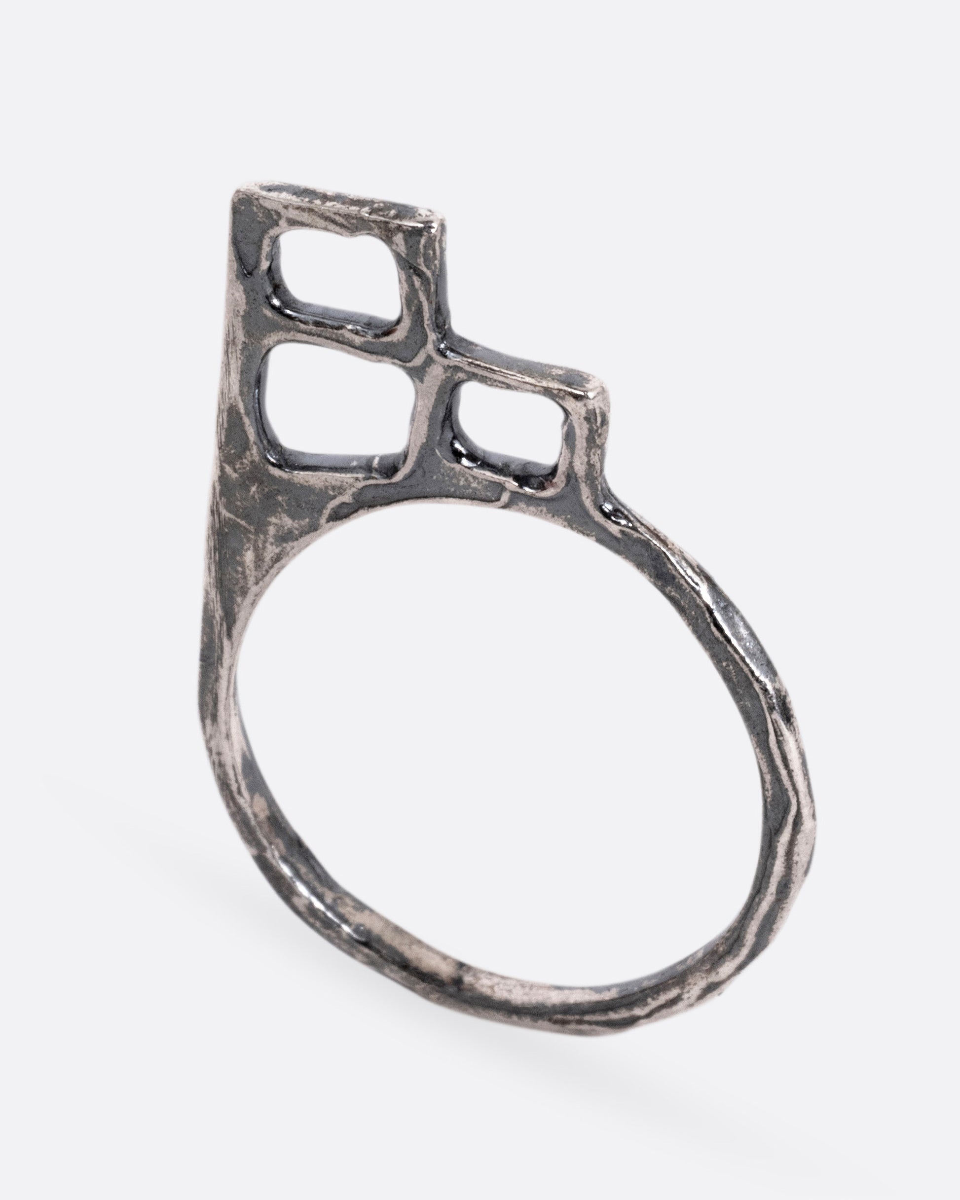 A silver ring with trio of stacked open windows, shown standing up from the front.