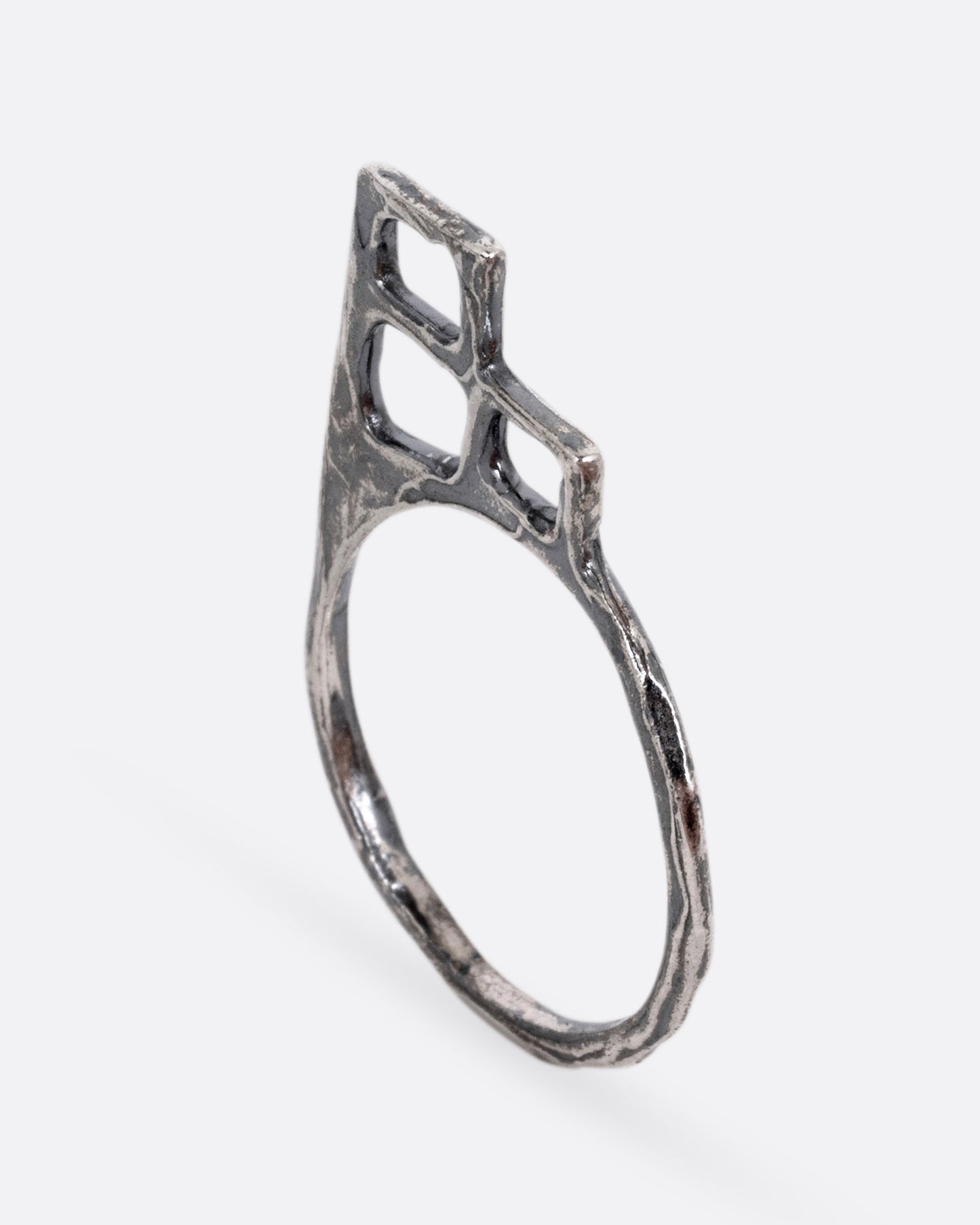A silver ring with trio of stacked open windows, shown from the side.