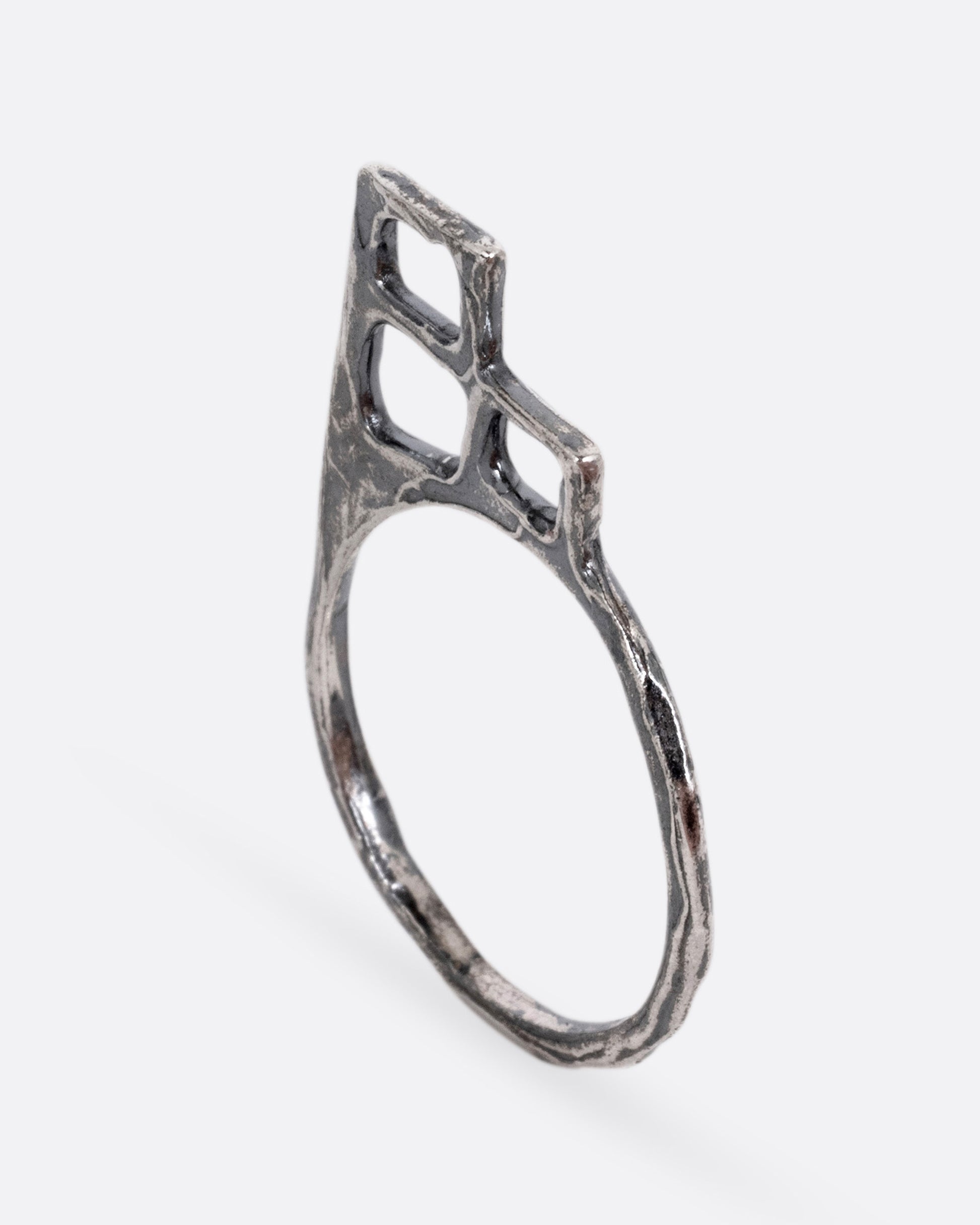 A silver ring with trio of stacked open windows, shown from the side.