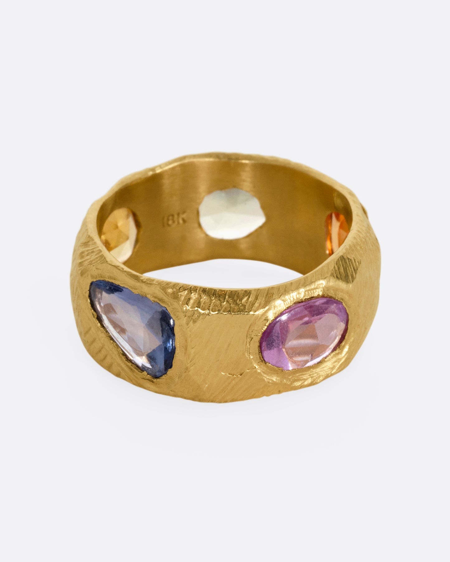 A yellow gold band with rose cut multicolor sapphires all the way around.