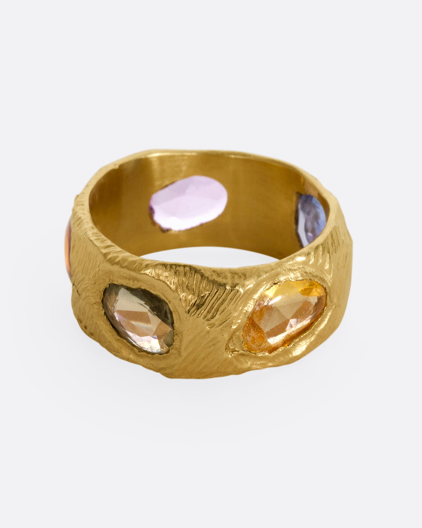 A yellow gold band with rose cut multicolor sapphires all the way around.