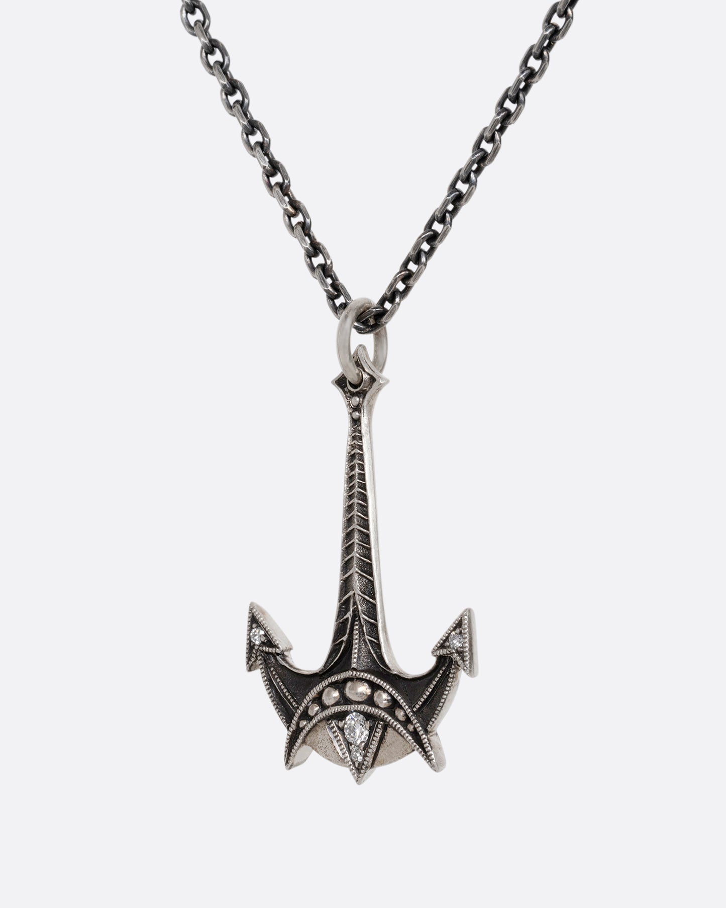 A sterling silver necklace with an anchor pendant and diamond details. Shown from the side.