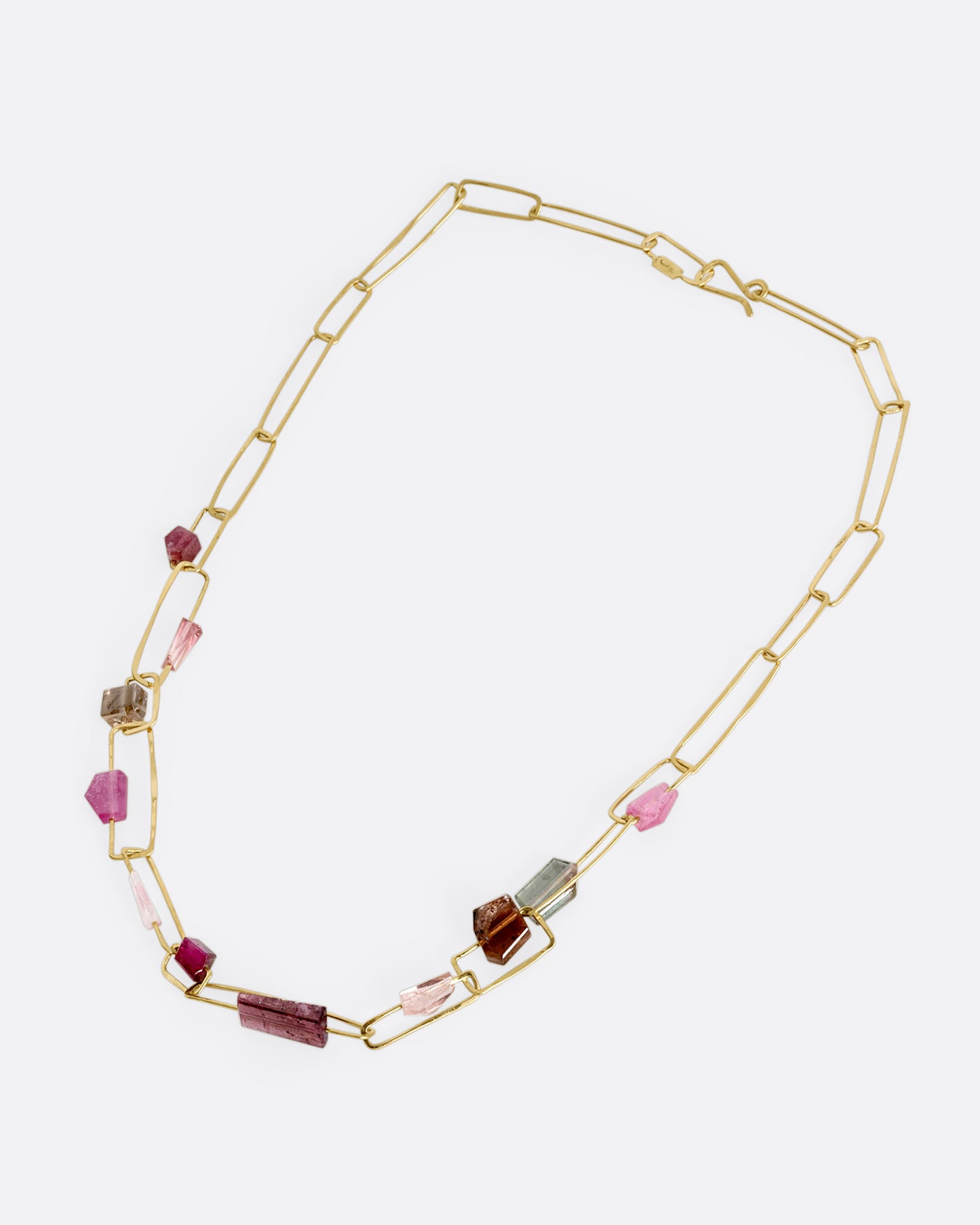 A yellow gold rectangular link necklace with multicolor and shape tourmalines. Shown laying flat.