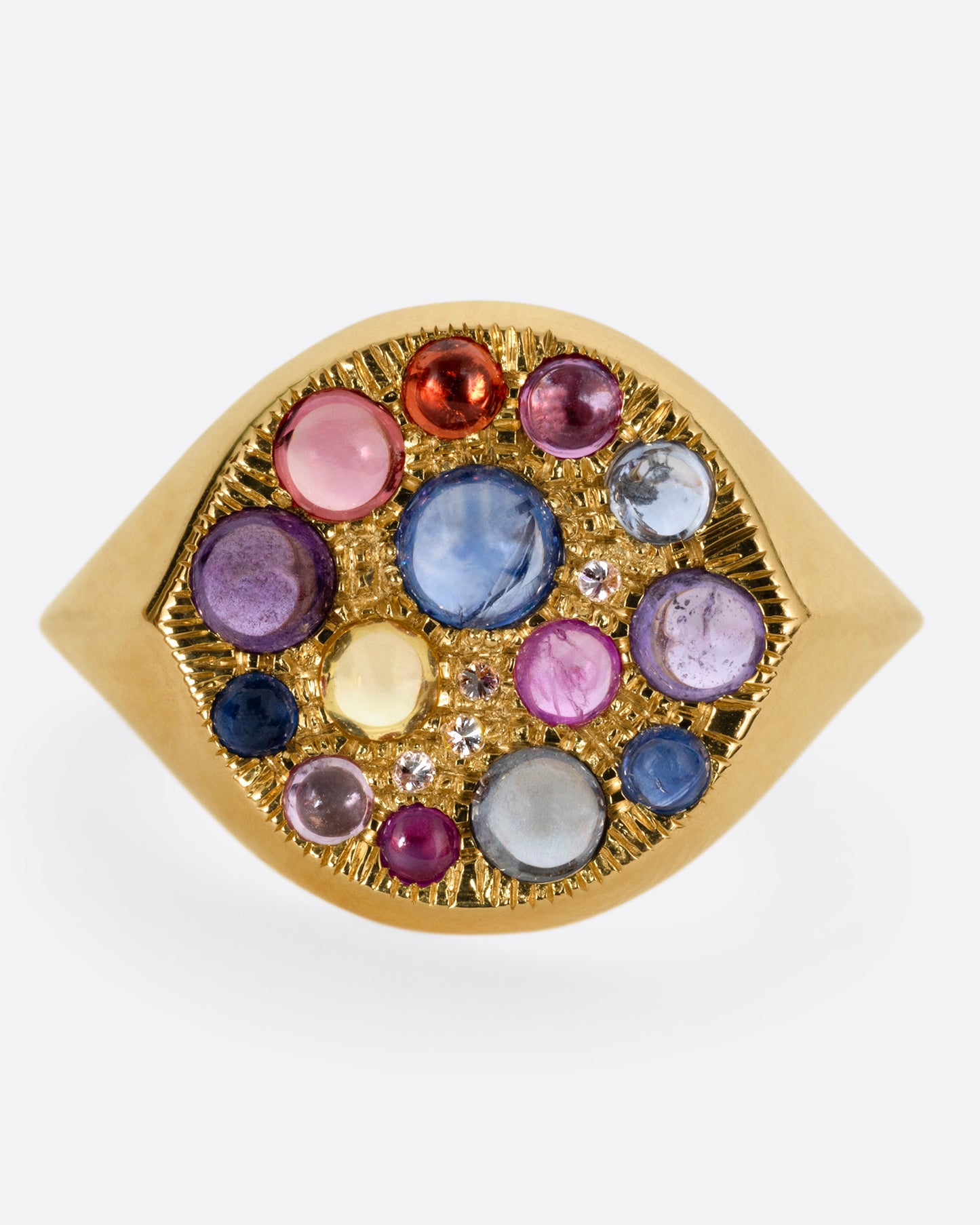 A yellow gold eye shaped ring with sapphire cabochons and diamonds, shown from the front.