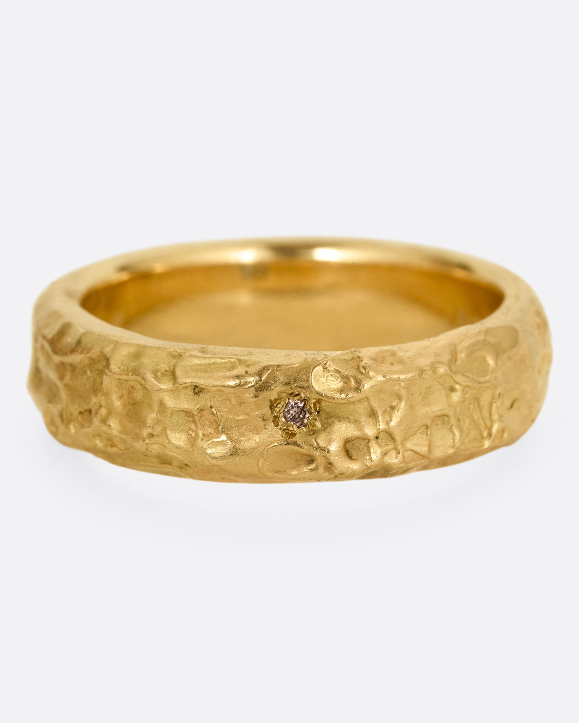 A textured yellow gold band with a brown diamond, shown from the front.