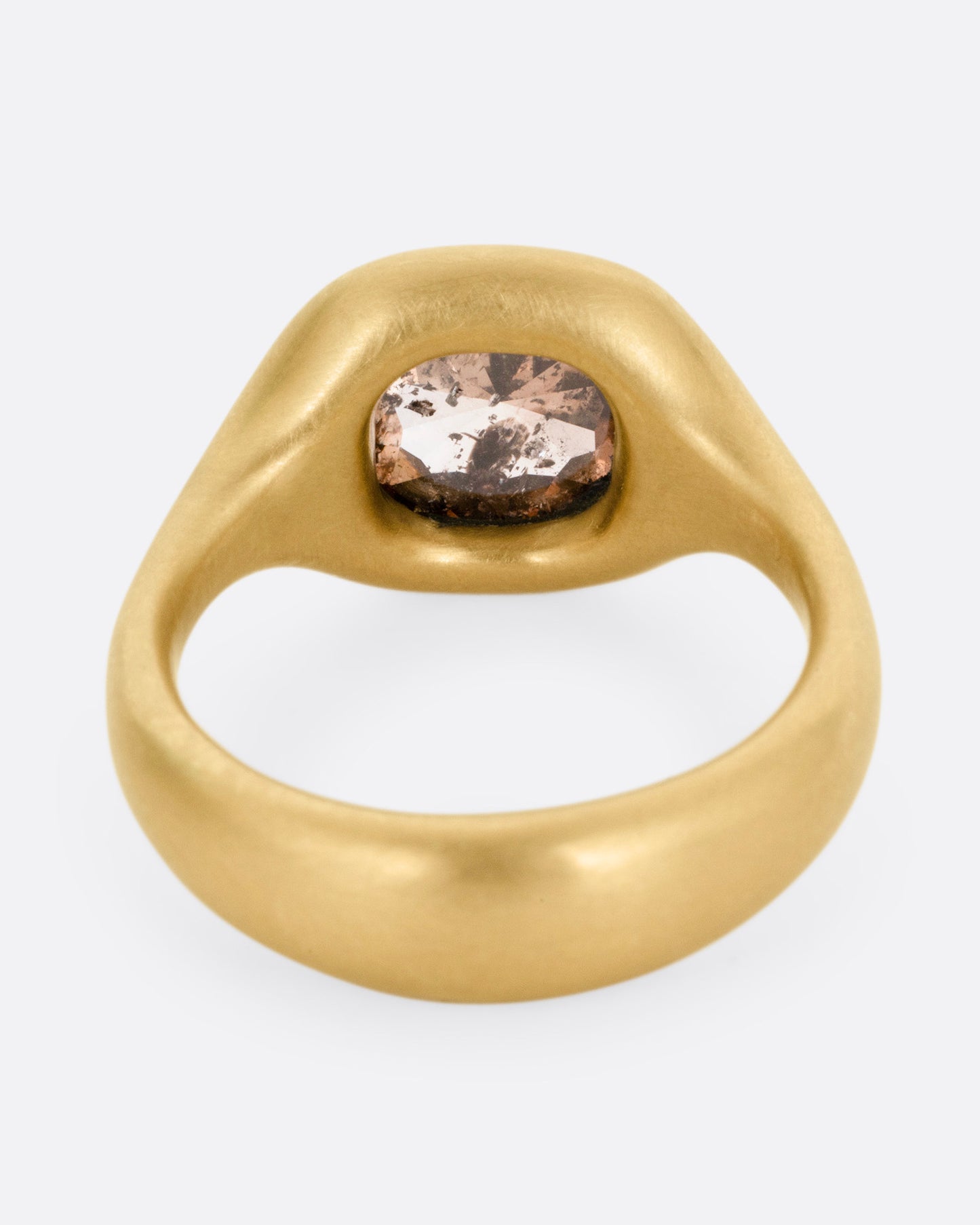 A yellow gold ring with a cognac diamond, shown from the back.
