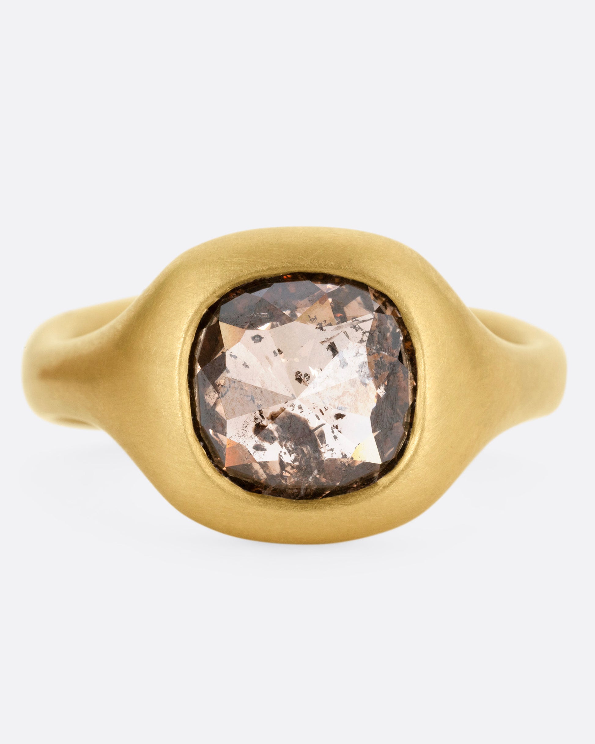 A yellow gold ring with a cognac diamond, shown from the front.