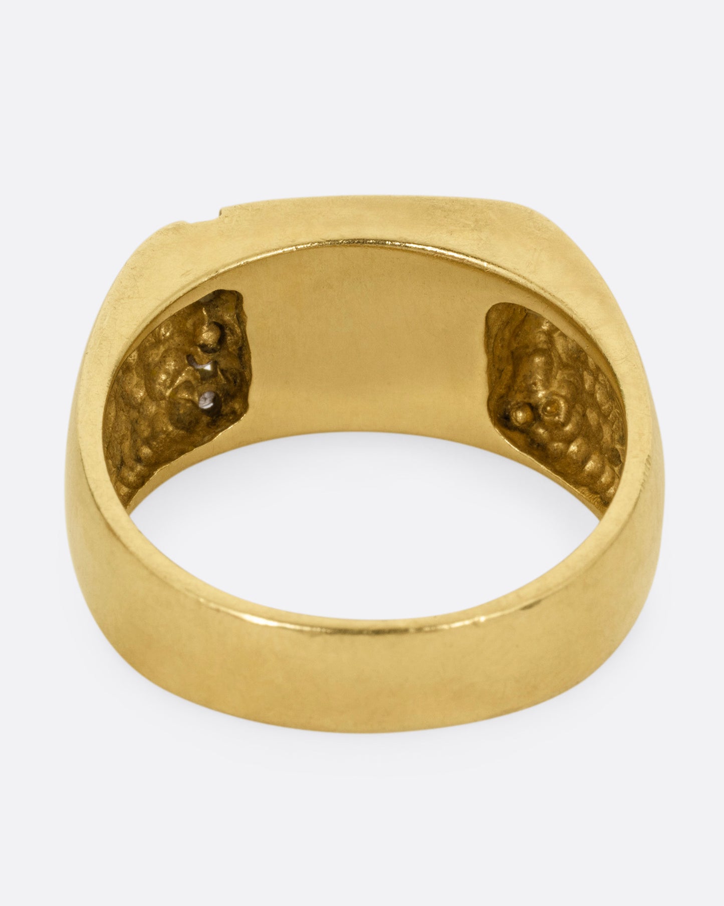 A yellow gold ring with a column of diamonds and a black enamel rectangle, shown from the back.