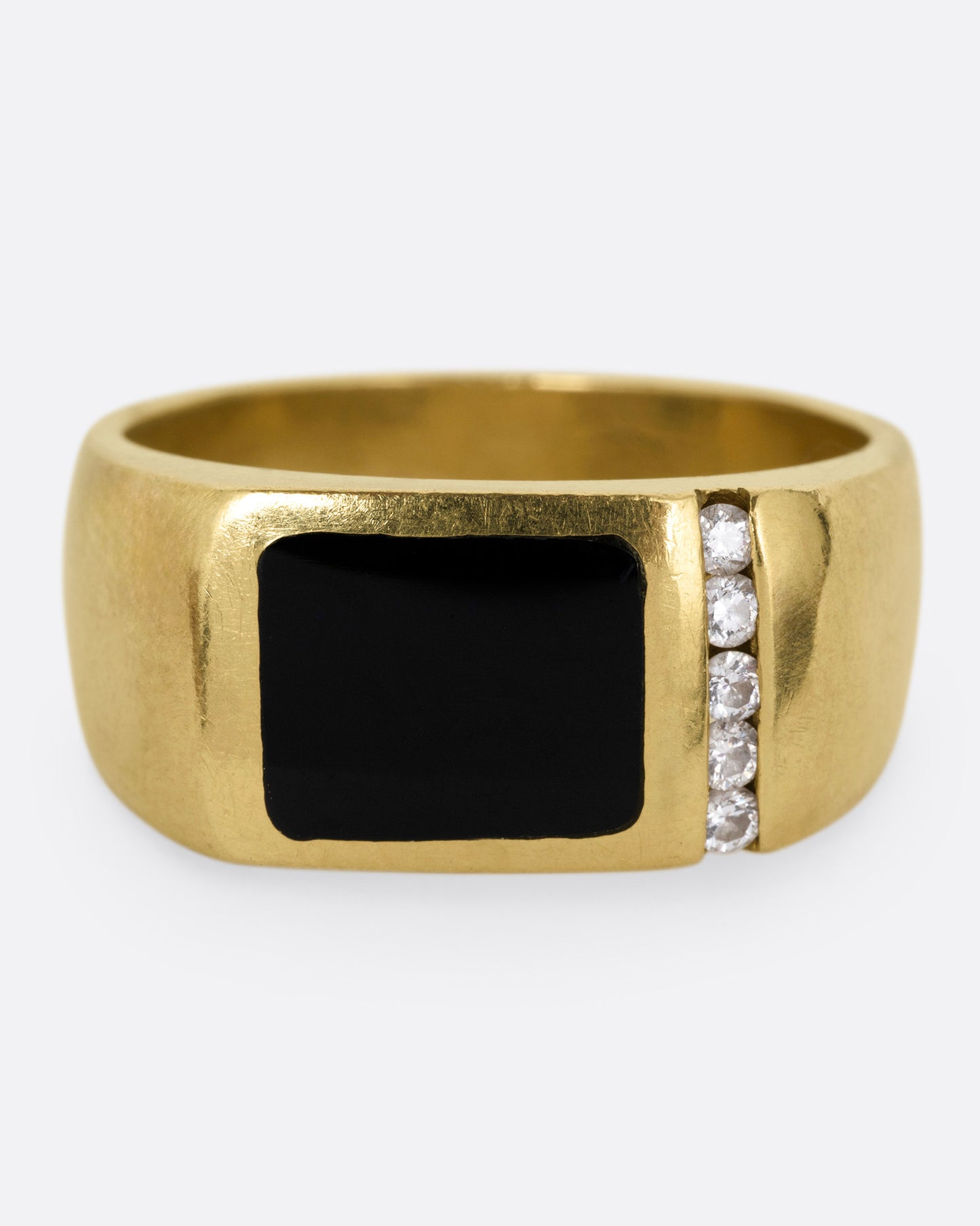 A yellow gold ring with a column of diamonds and a black enamel rectangle, shown from the front.