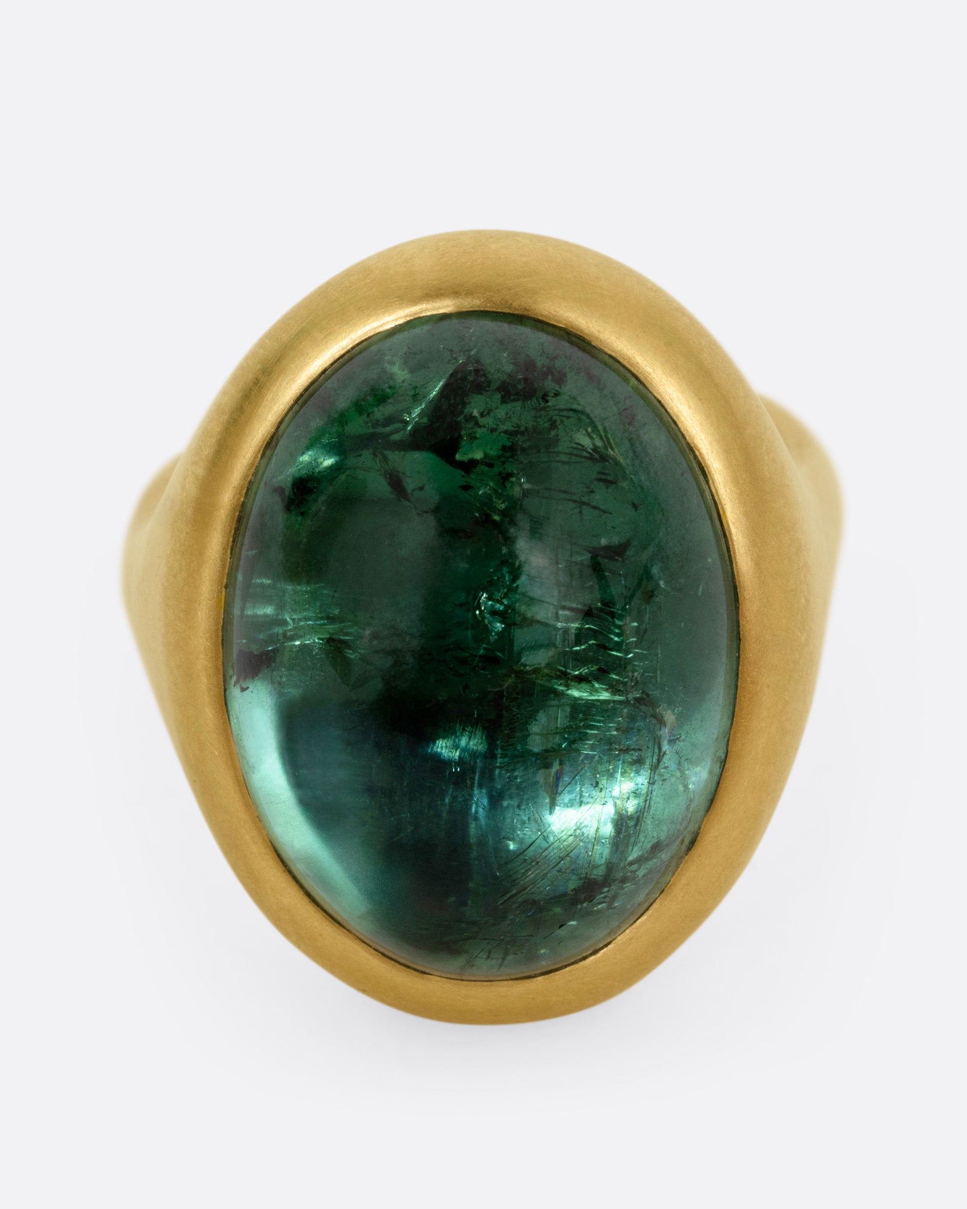 A yellow gold ring with a green tourmaline cabochon, shown from the front.