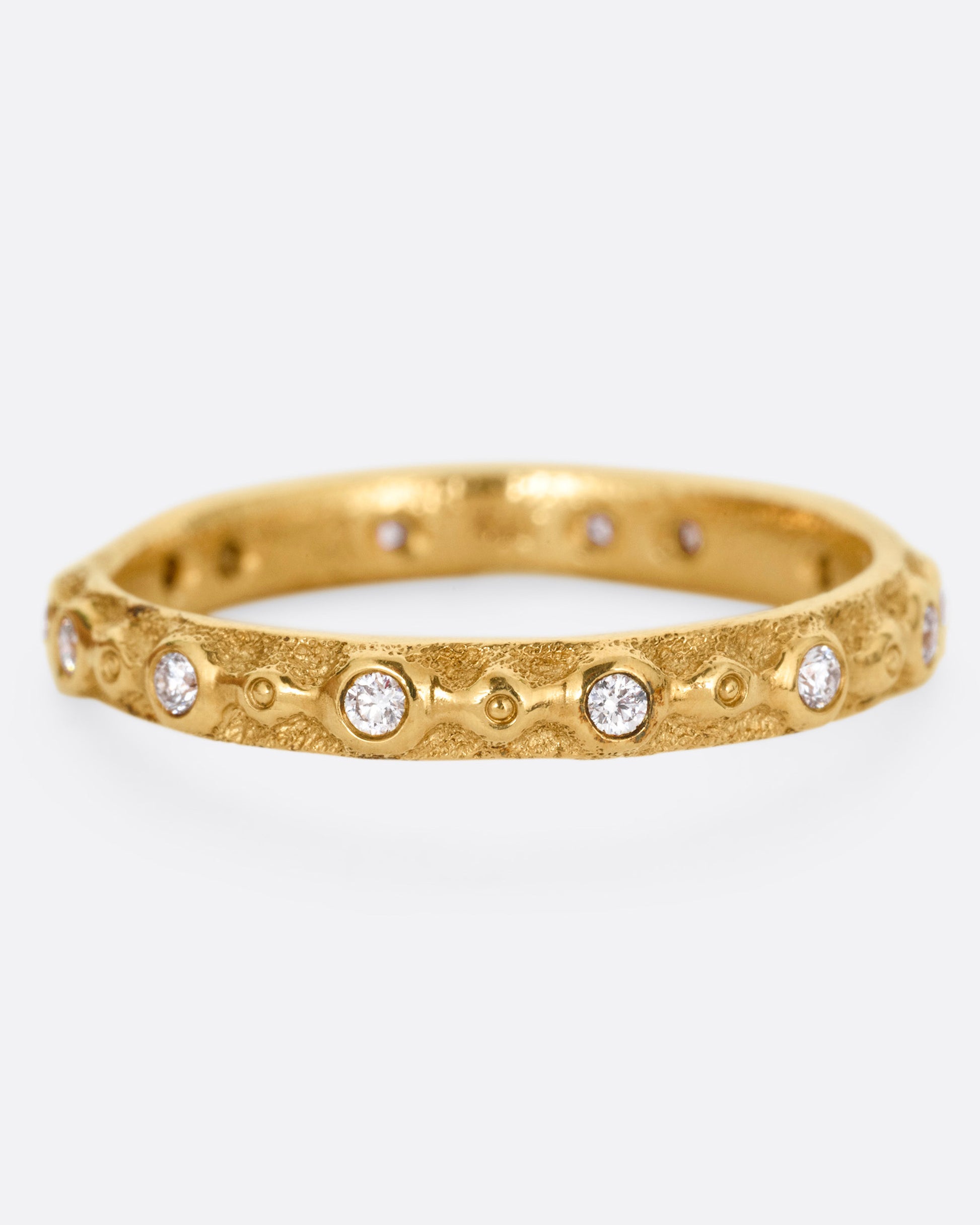 A textured yellow gold ring with white diamonds. Shown from the front.