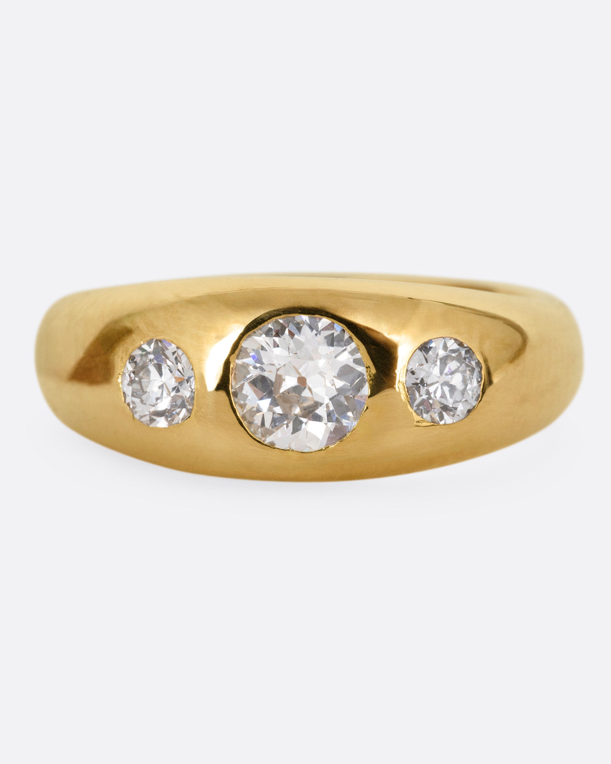 A yellow gold ring with three diamonds, shown from the front.