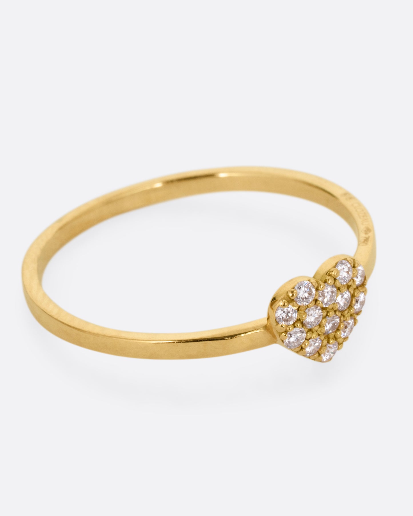 A yellow gold ring with a diamond studded heart. Shown from the side.