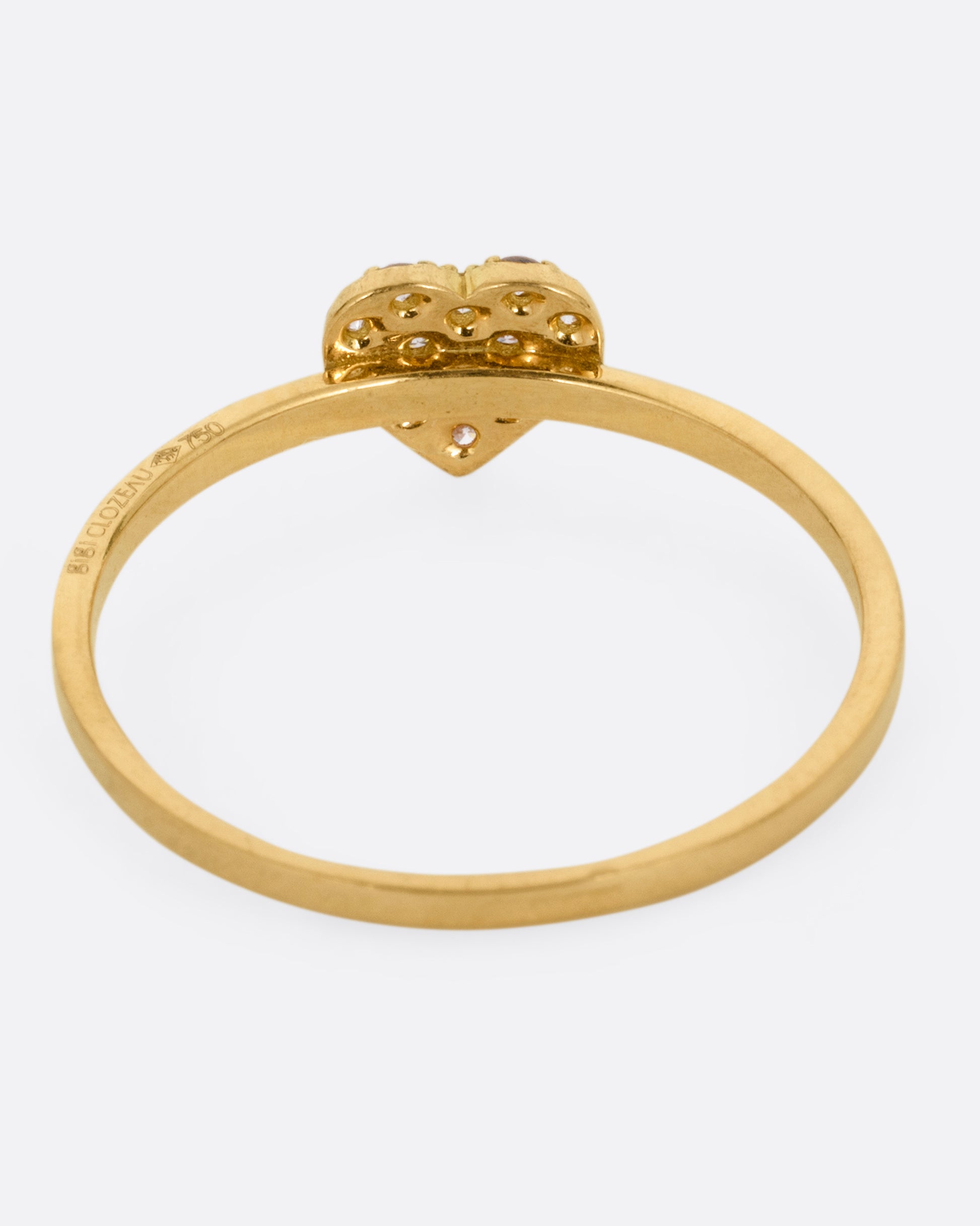 A yellow gold ring with a diamond studded heart. Shown from the back.