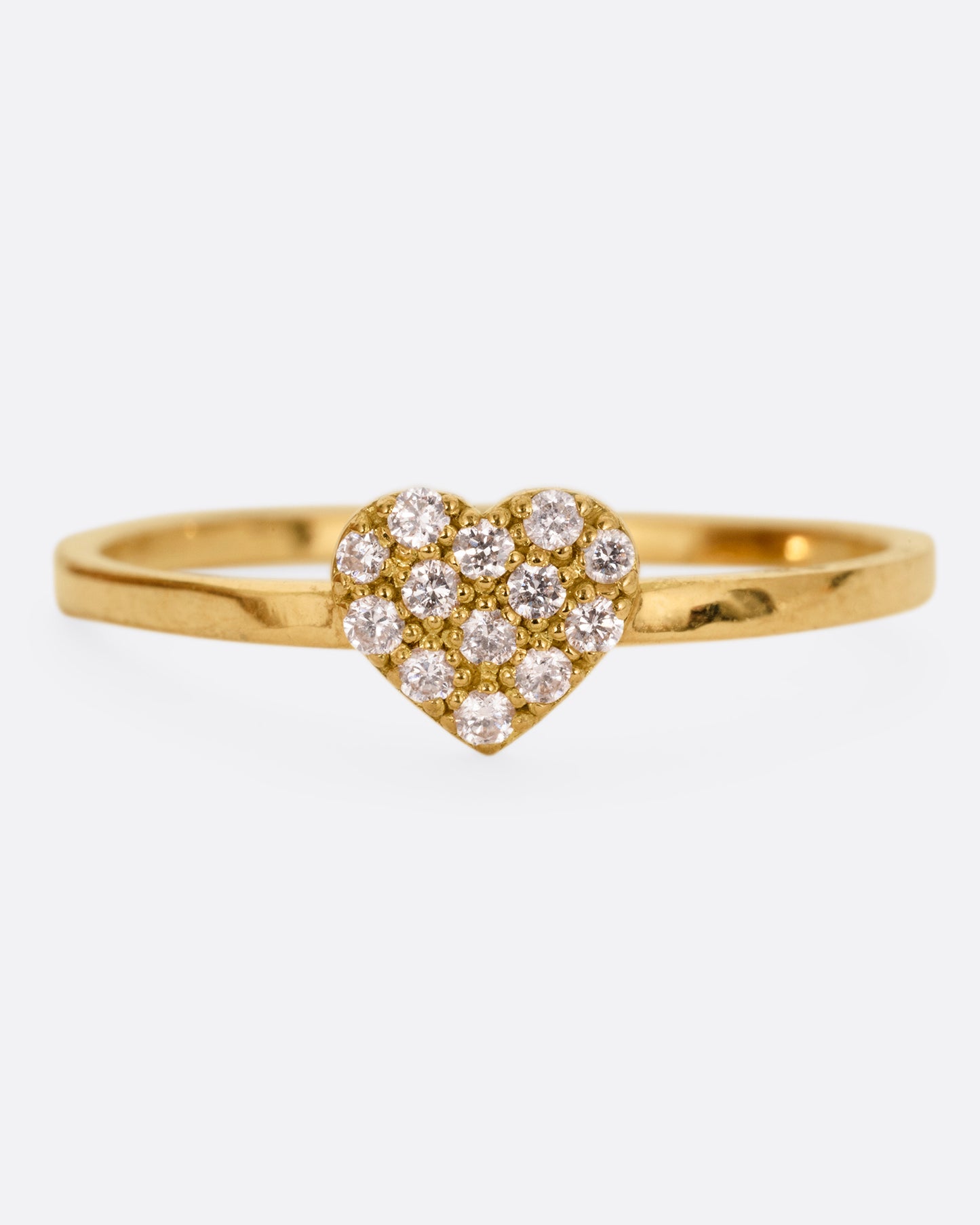 A yellow gold ring with a diamond studded heart. Shown from the front.