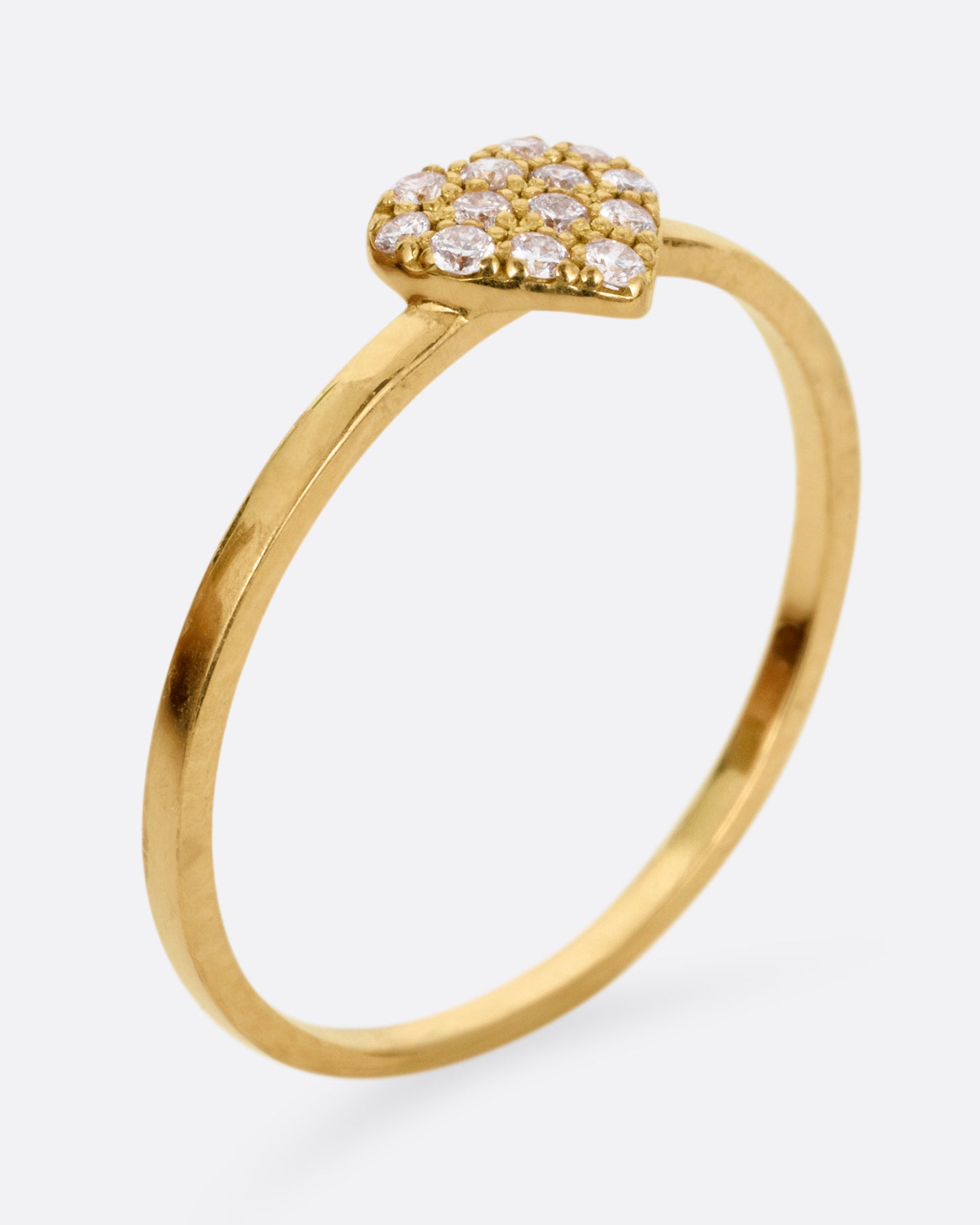 A yellow gold ring with a diamond studded heart. Shown from the side standing up.