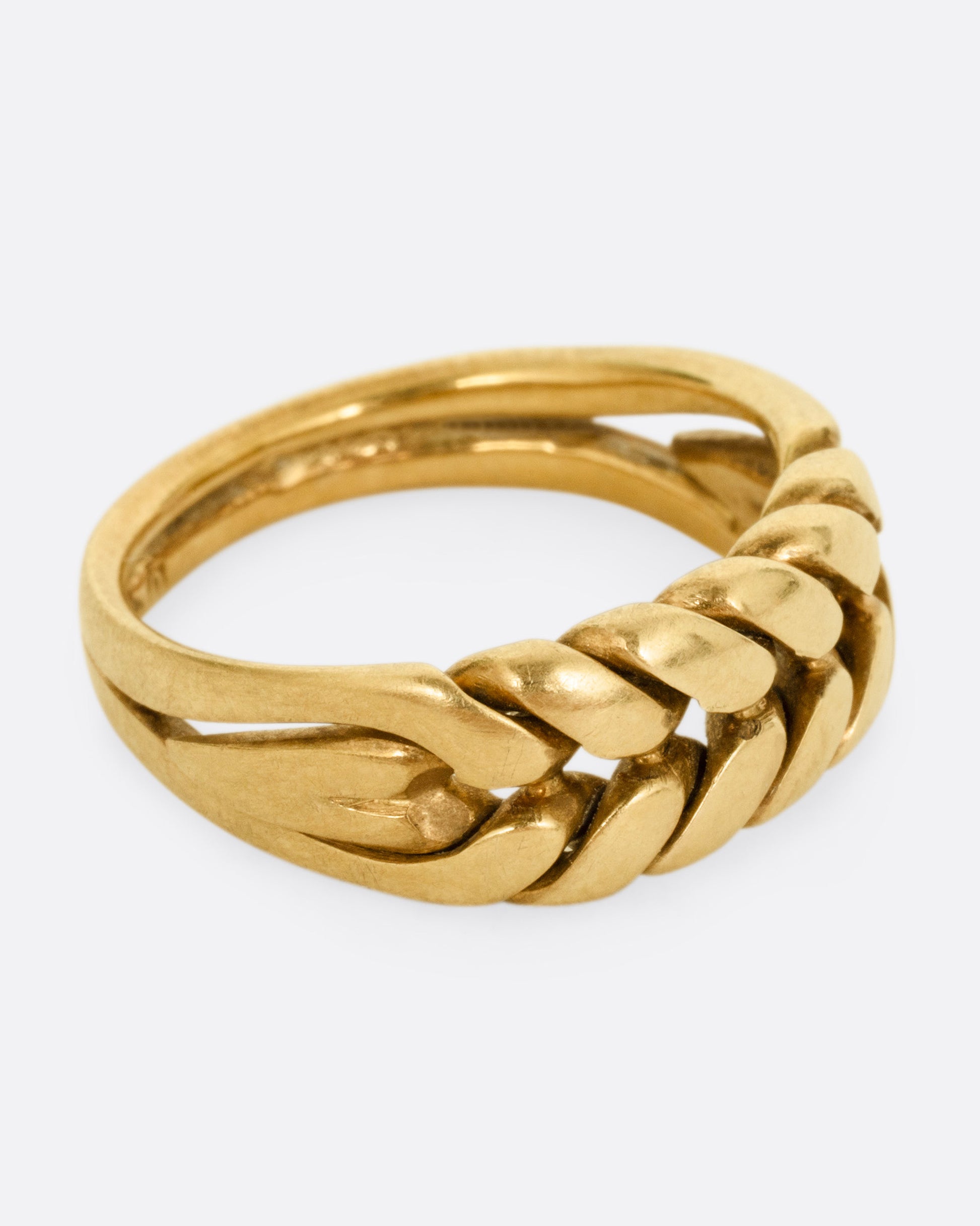 A yellow gold ring with a braided front. Shown from the side.