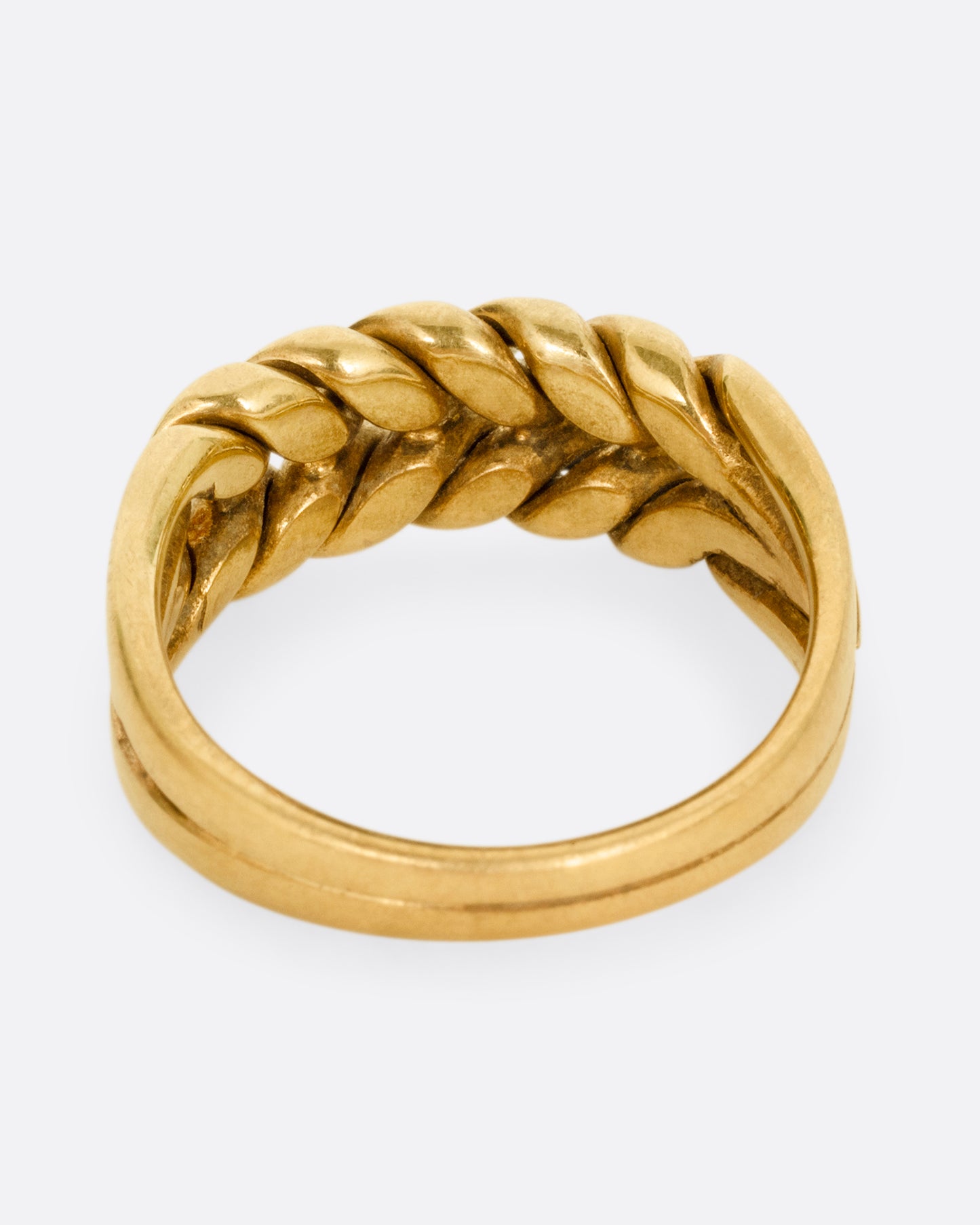 A yellow gold ring with a braided front. Shown from the back.