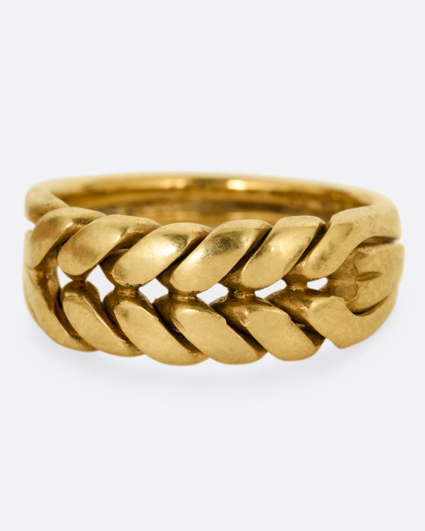 A yellow gold ring with a braided front. Shown from the front.