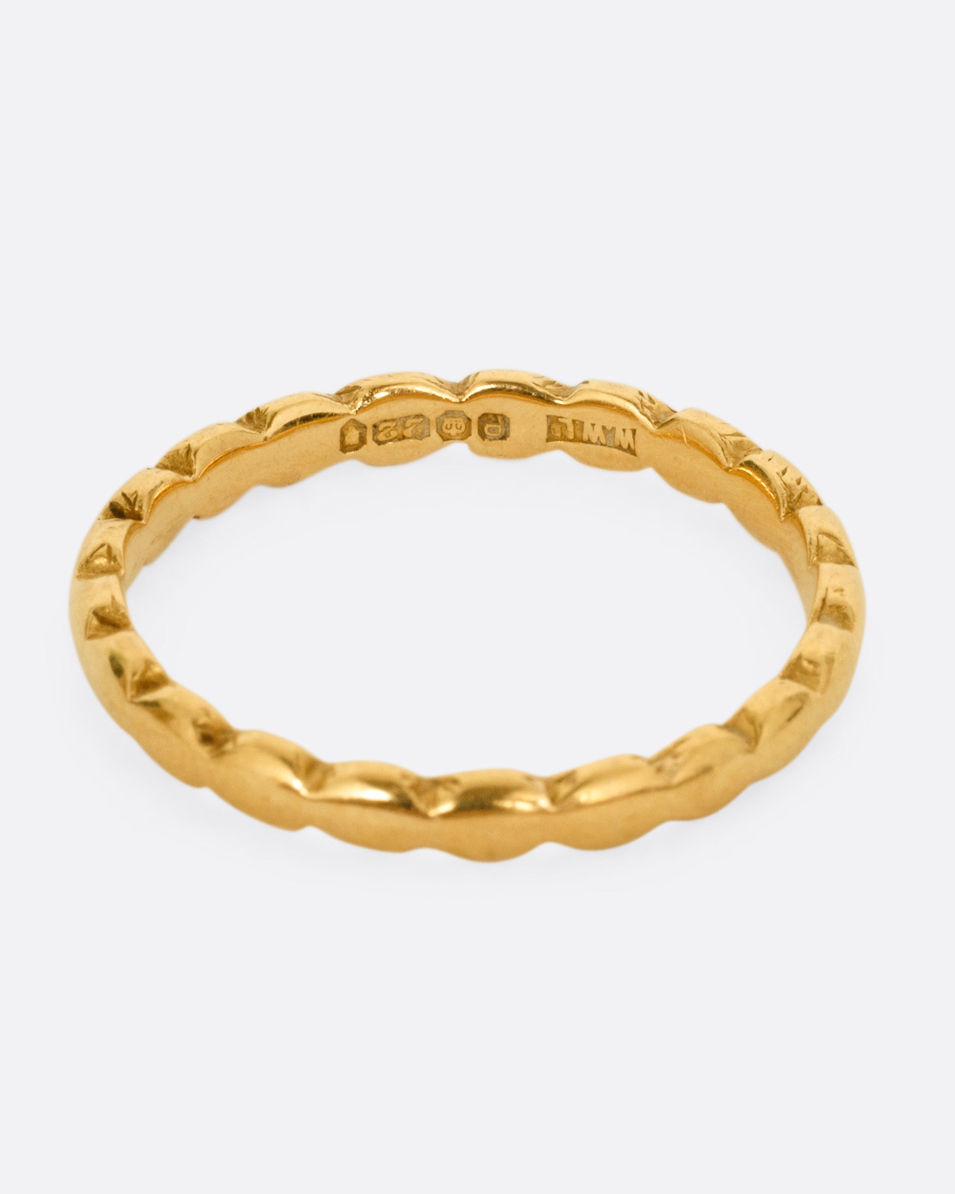 A yellow gold ring with scalloped edges. Shown from the front.