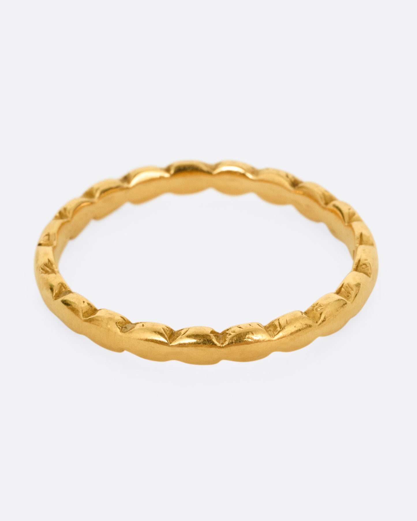 A yellow gold ring with scalloped edges. Shown from the front.