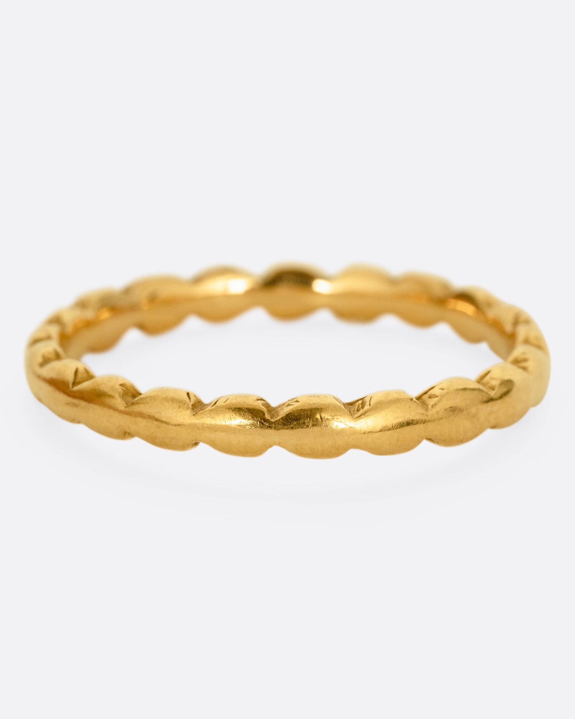 A yellow gold ring with scalloped edges. Shown from the front.