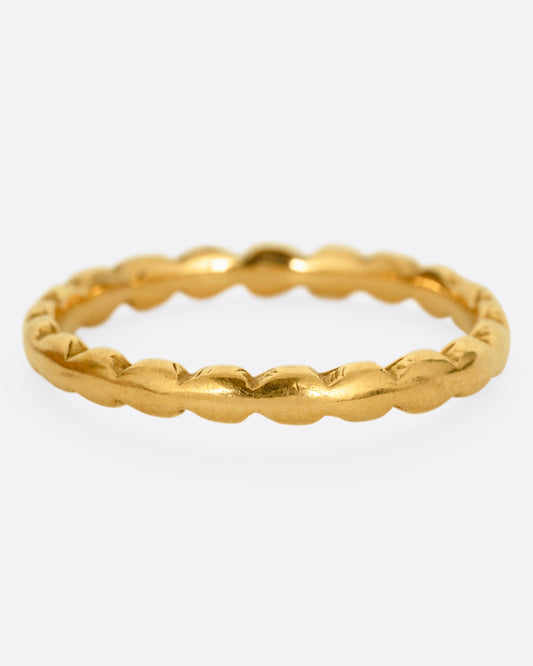 A yellow gold ring with scalloped edges. Shown from the front.