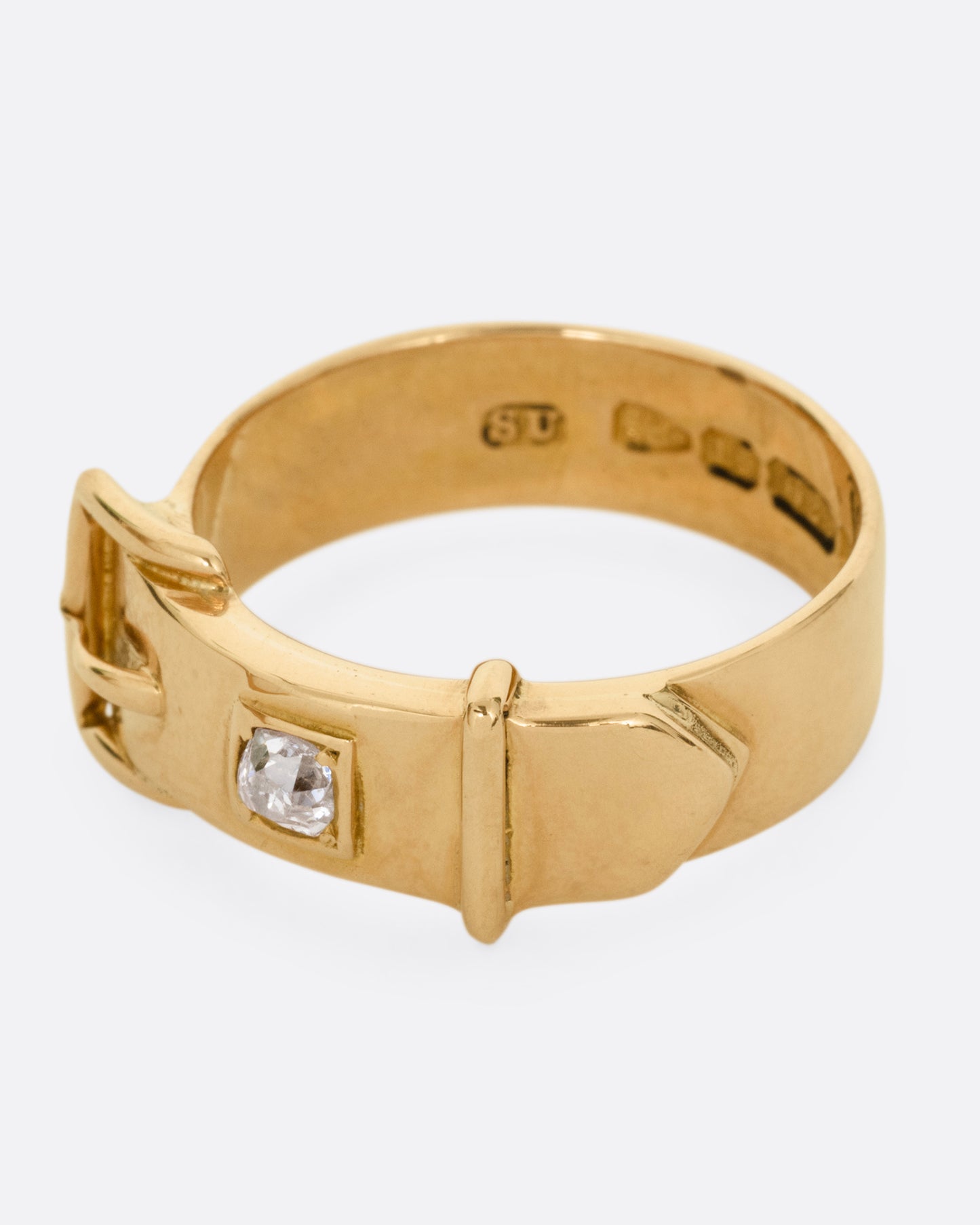 A yellow gold Victorian remembrance buckle ring with an old mine cut diamond. Shown from the side.