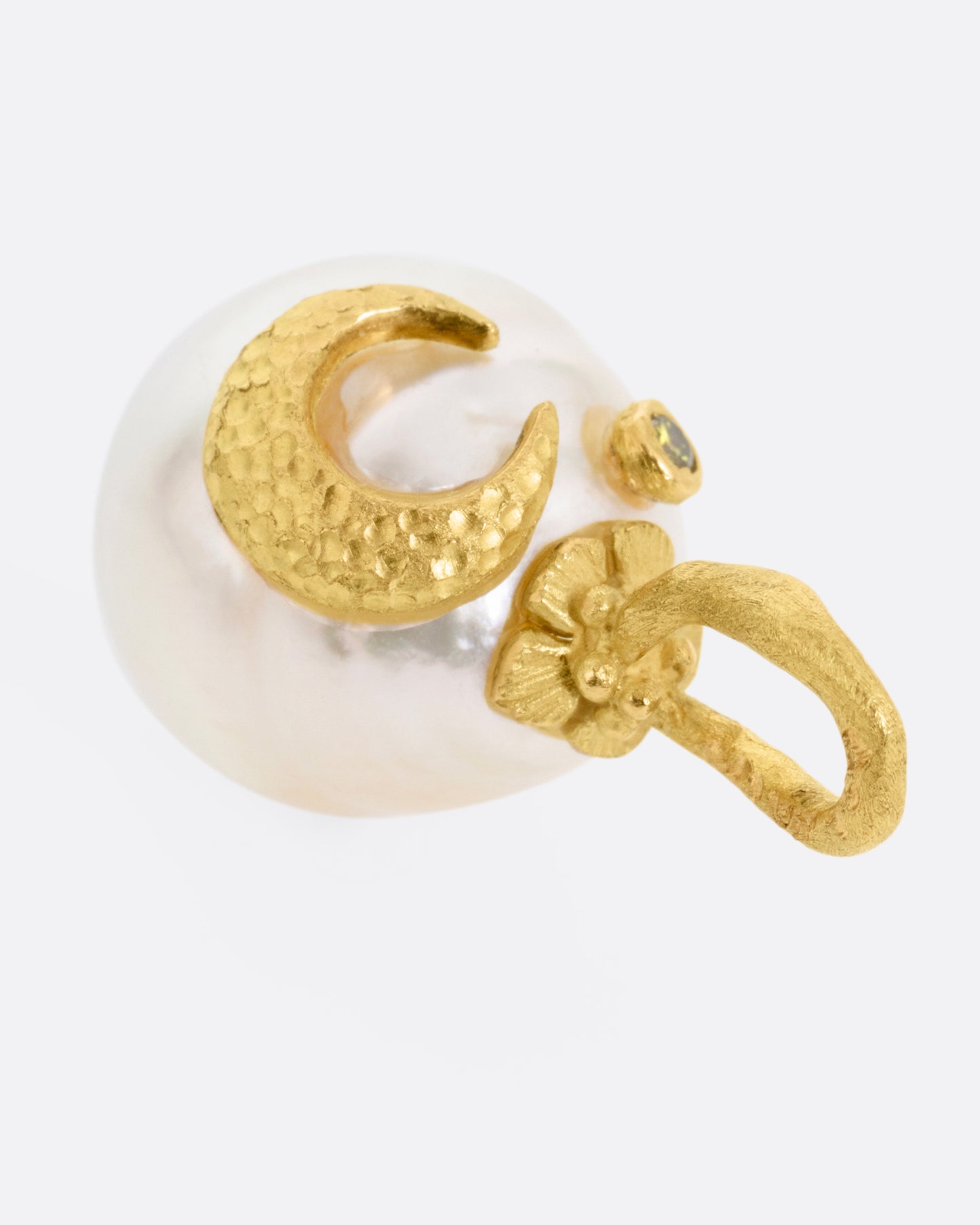 A yellow gold South Sea pearl pendant with a floral vine bail, a crescent moon, and a tiny diamond star. Shown from the side.