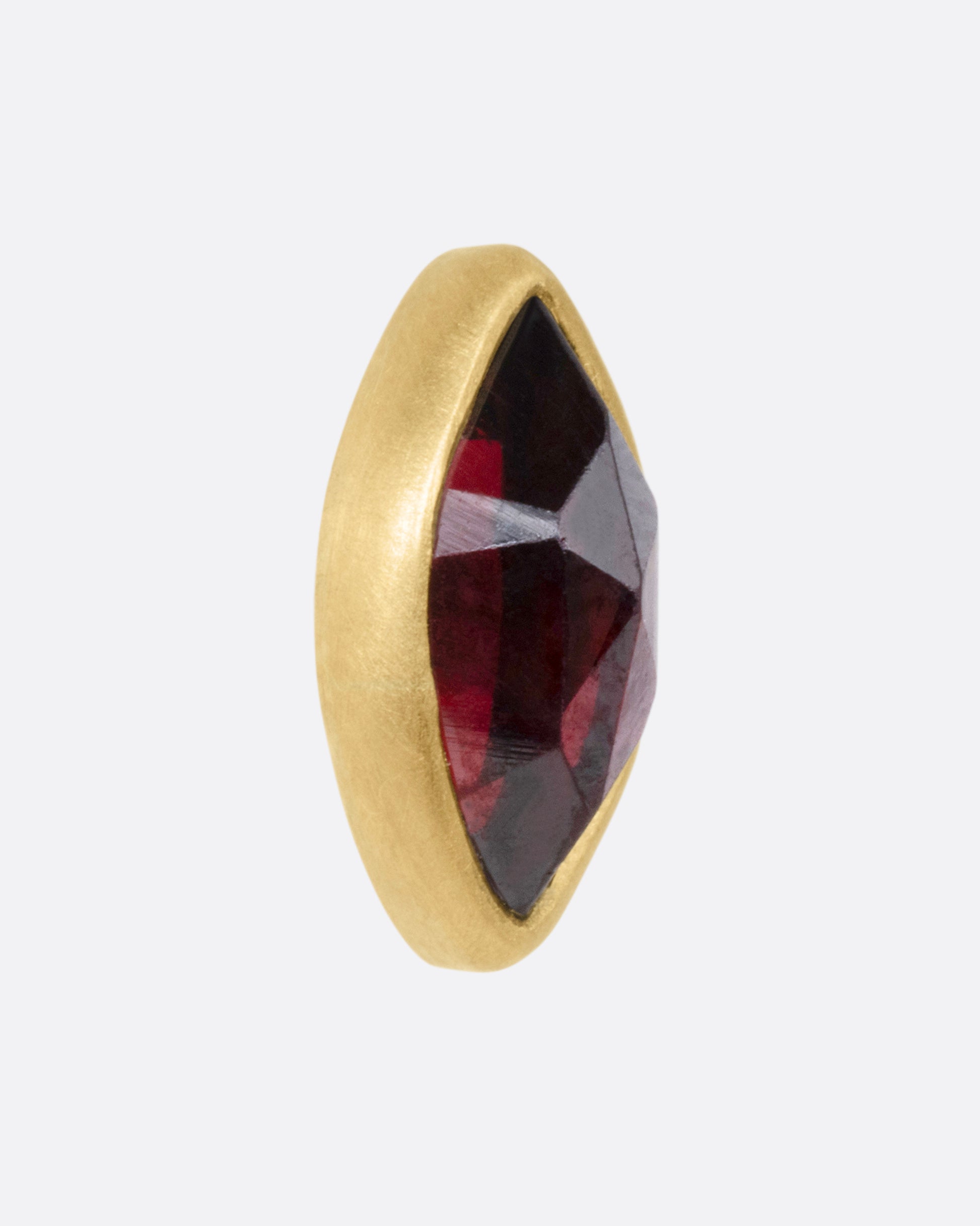 A yellow gold navette garnet earring, shown from the side.