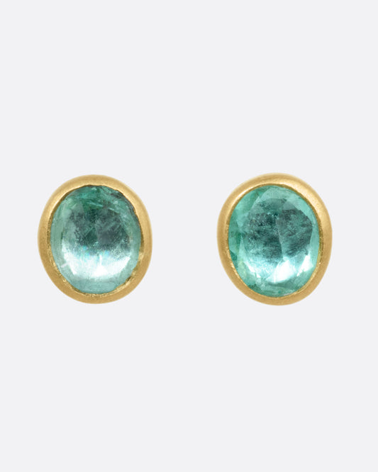 A pair of yellow gold stud earrings with Colombian emeralds, shown from the front.