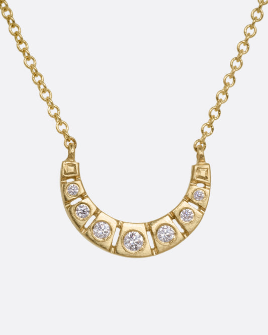 A yellow gold necklace with a crescent moon studded with brilliant cut diamonds, shown from the front.