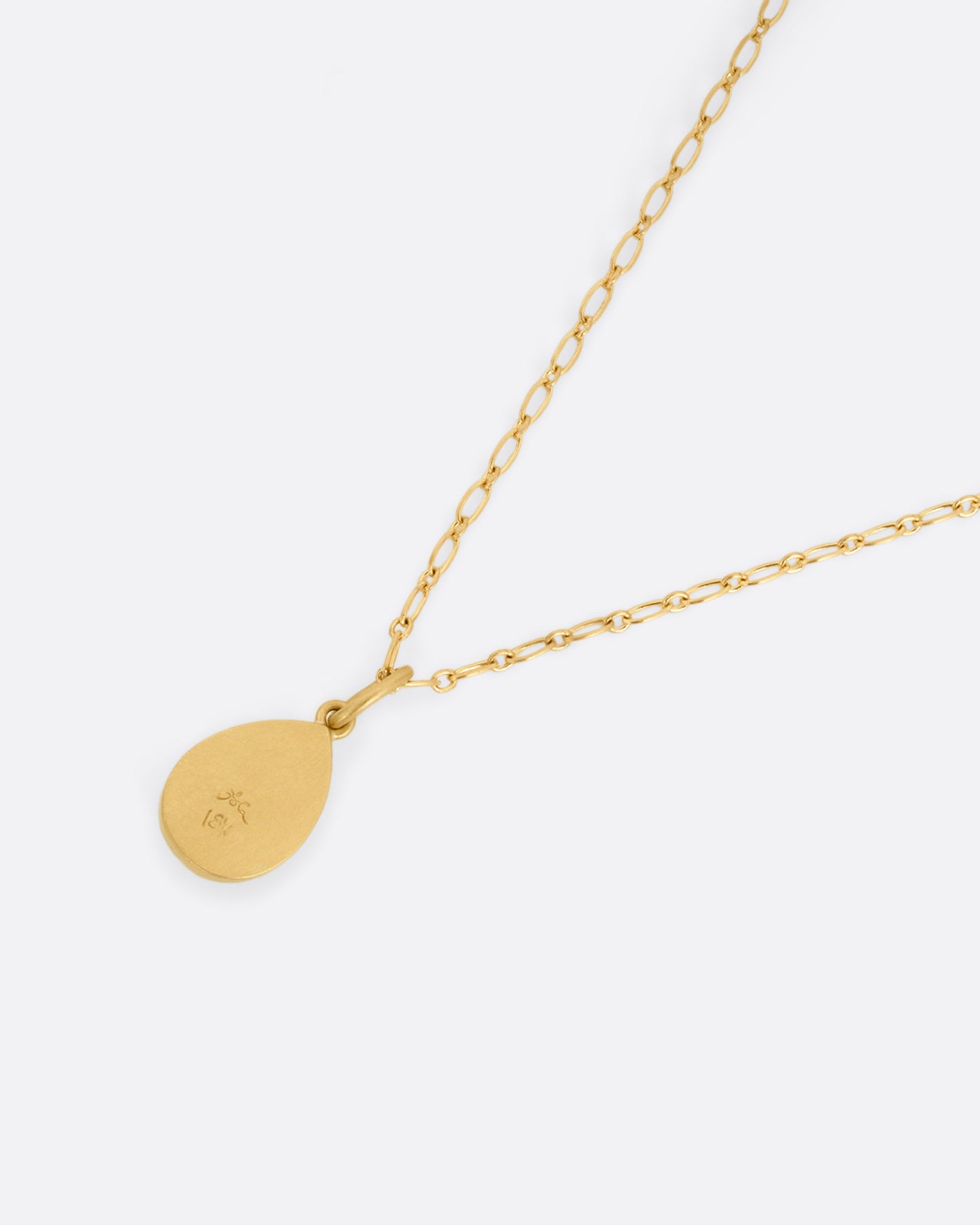A yellow gold elongated link cable chain necklace with a teardrop shaped salt and pepper diamond, shown from the back.