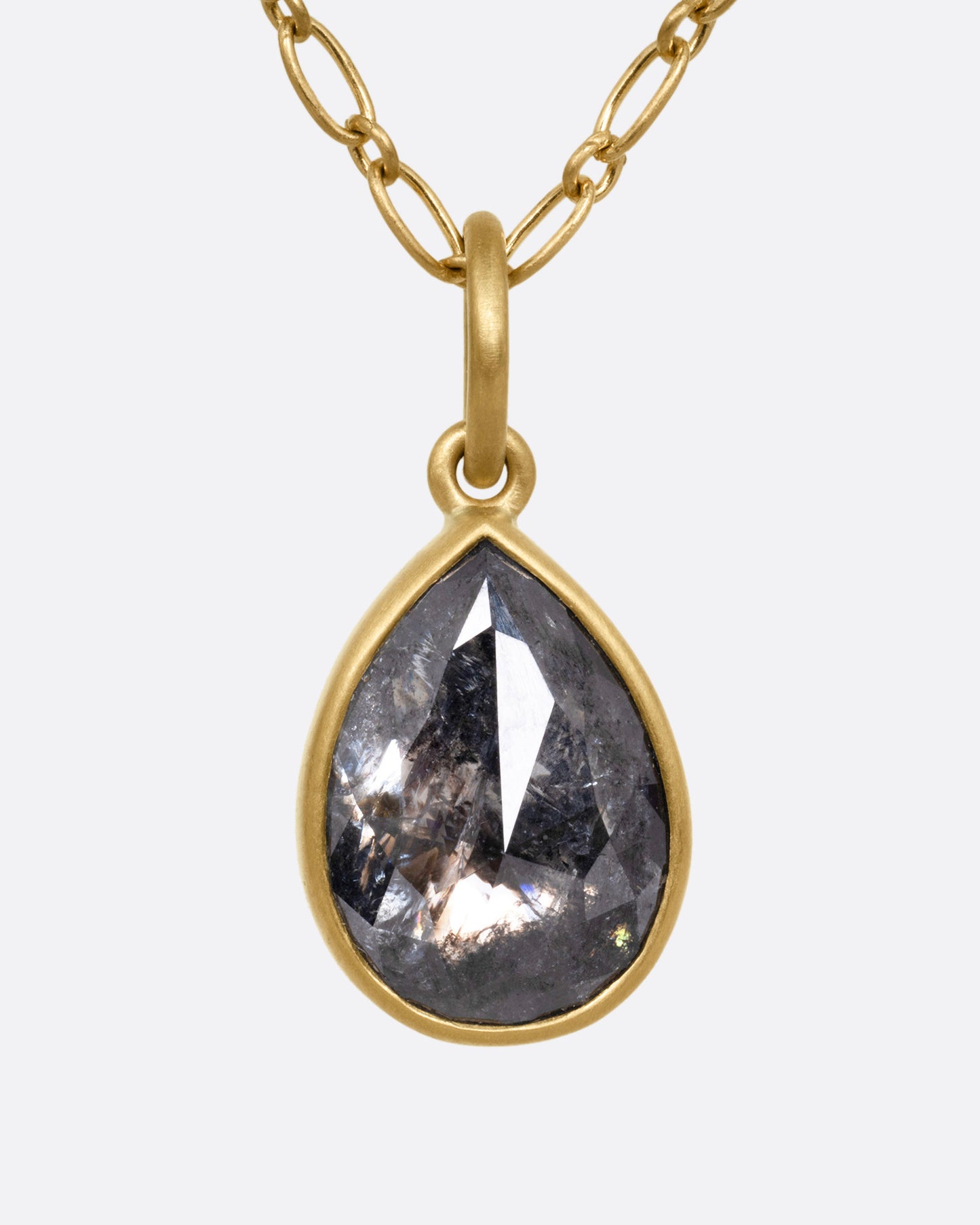 A yellow gold elongated link cable chain necklace with a teardrop shaped salt and pepper diamond, shown from the front.