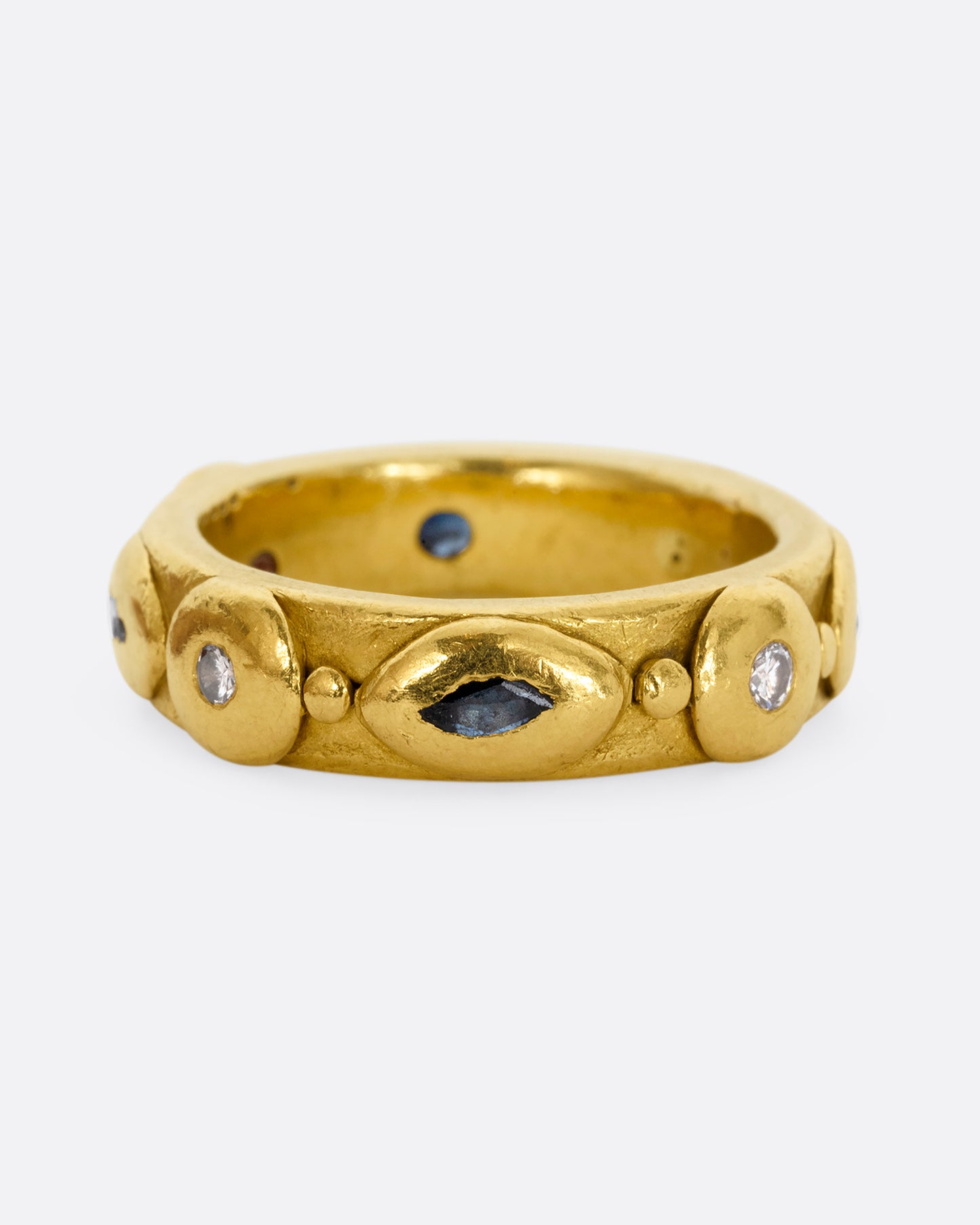 A high karat yellow gold ring with marquis blue sapphires and round diamonds all the way around.