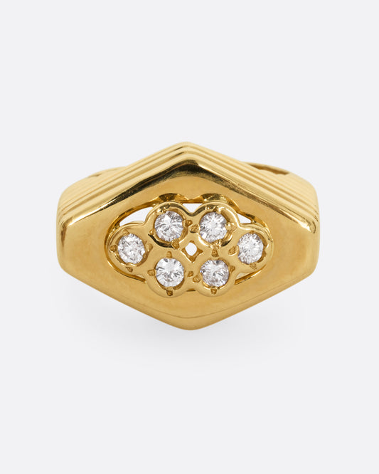 A yellow gold squared diamond shaped ring with a ribbed base and six round diamonds on the face. Shown from the front.